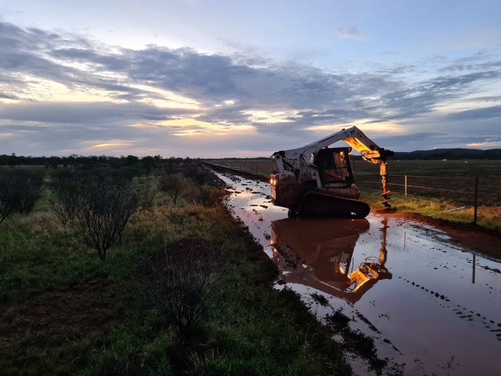 A bulldozer is driving down a muddy road.
