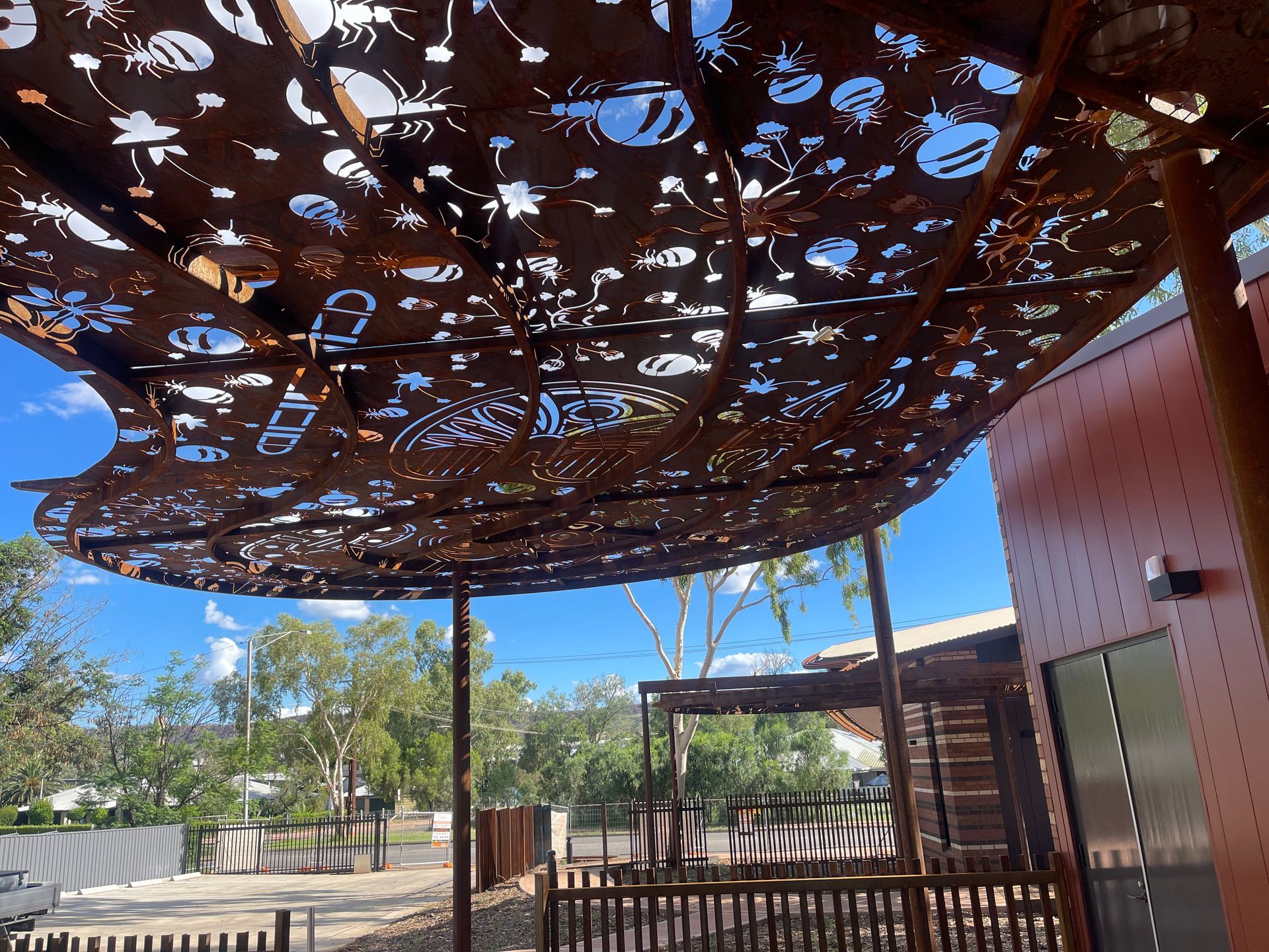 A roof with a lot of holes in it and a fence in the background.