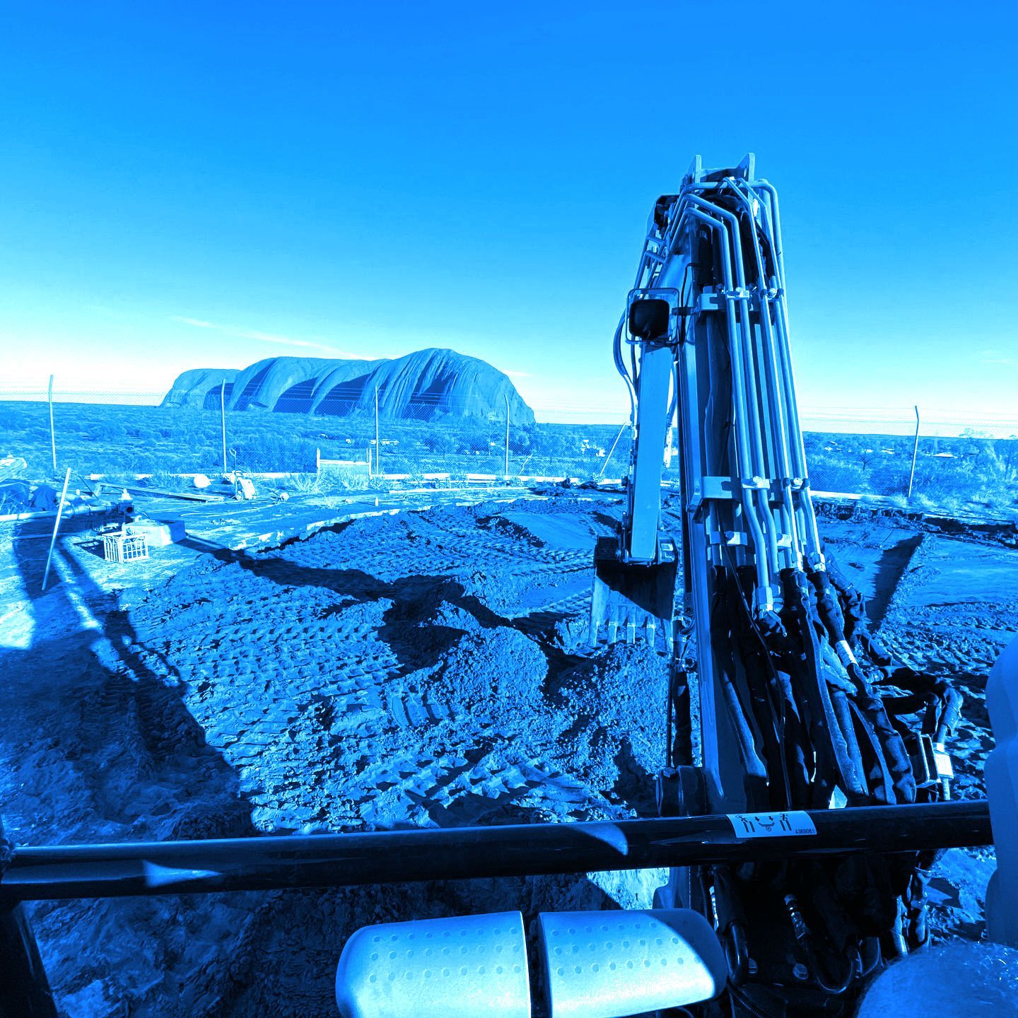 A large crane is sitting in front of a mountain in the distance