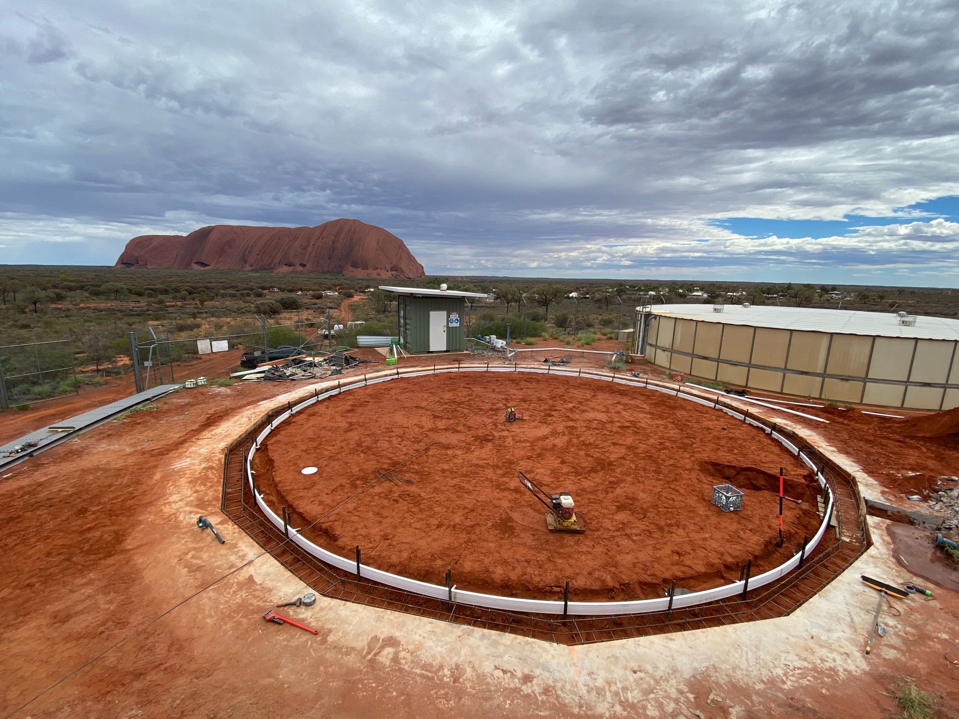 An aerial view of a construction site with a mountain in the background.