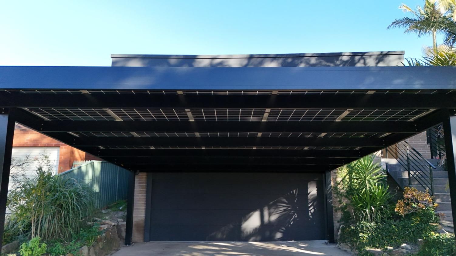 Black Carport with Solar Panels Over a Garage — Mid North Coast Solar Carports in Scotts Head, NSW