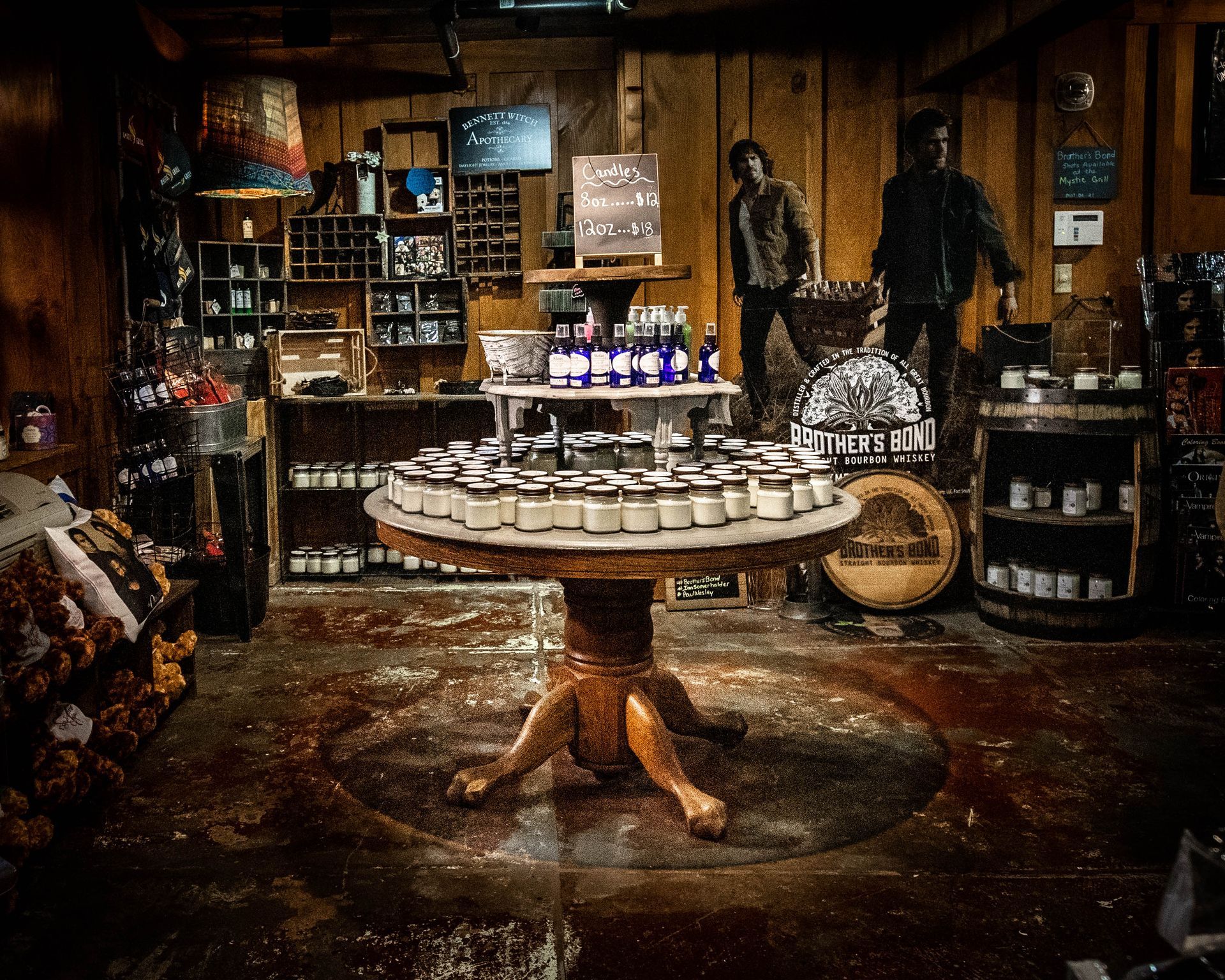 There is a table in the middle of the room with a lot of jars on it.