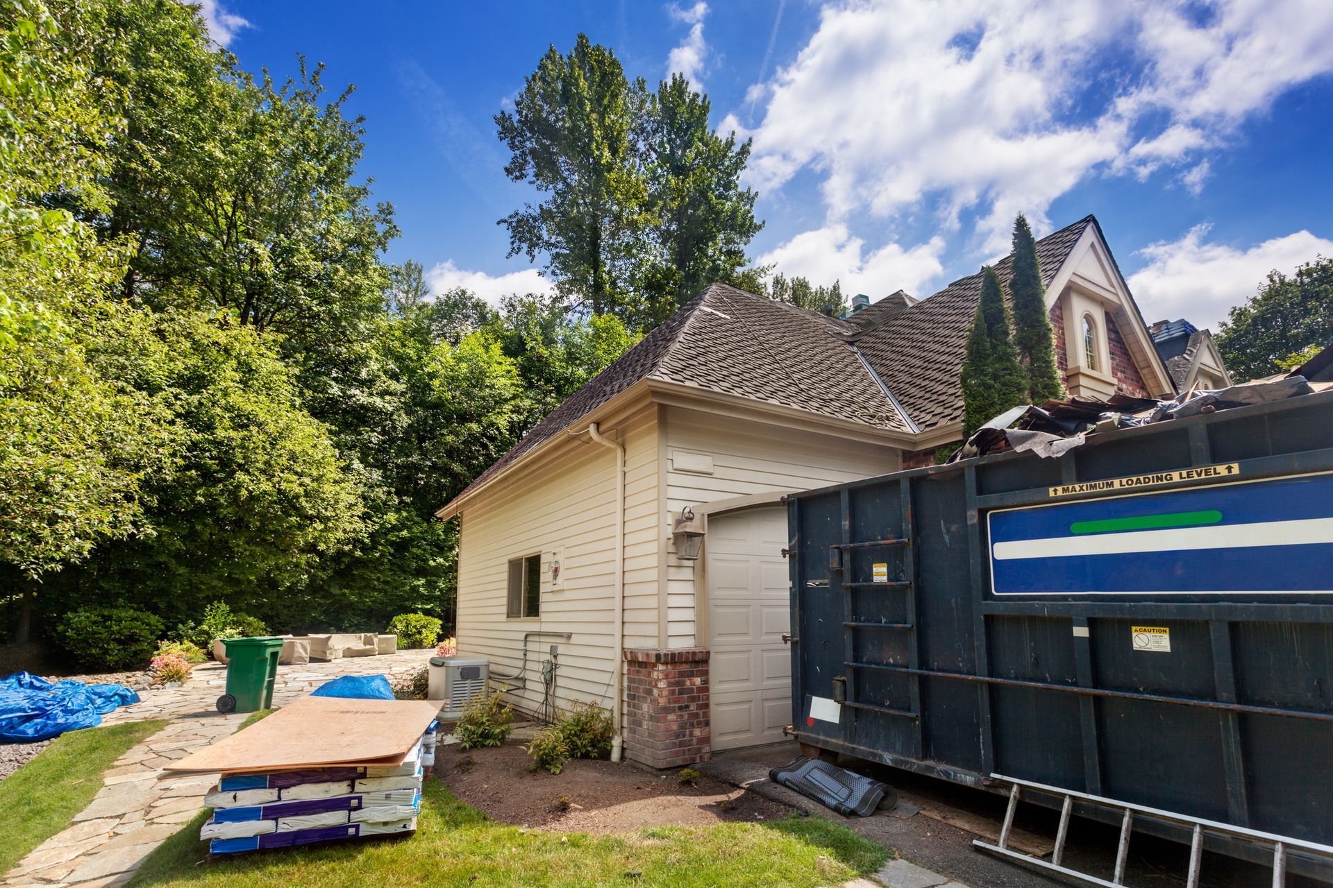 A roofing dumpster in Fort Myers, FL, from ESP Dumpsters, placed in front of a building for convenie