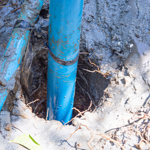 A blue pipe is sticking out of a hole in the ground