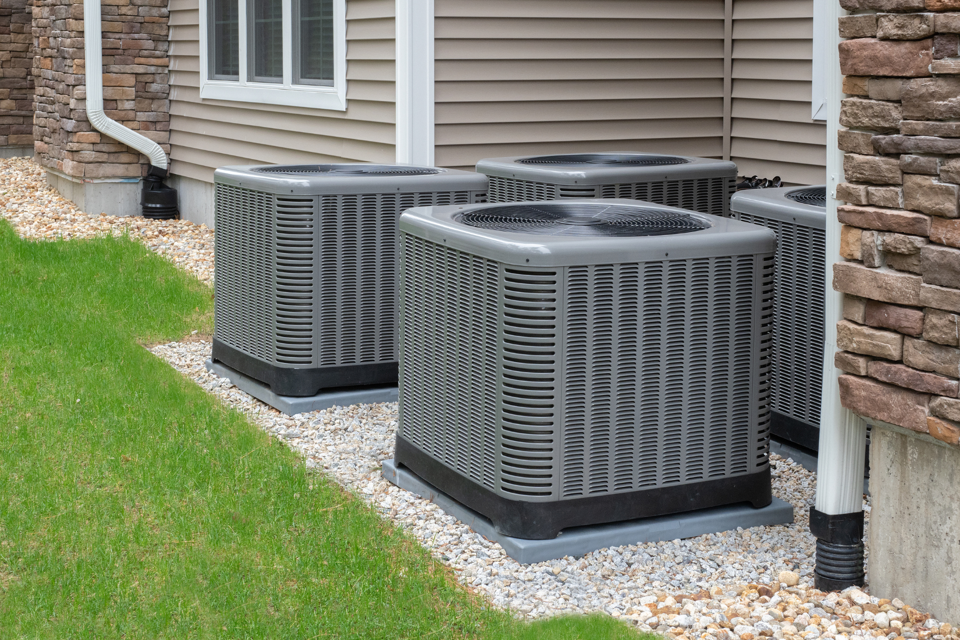 a row of air conditioners are sitting outside of a house .