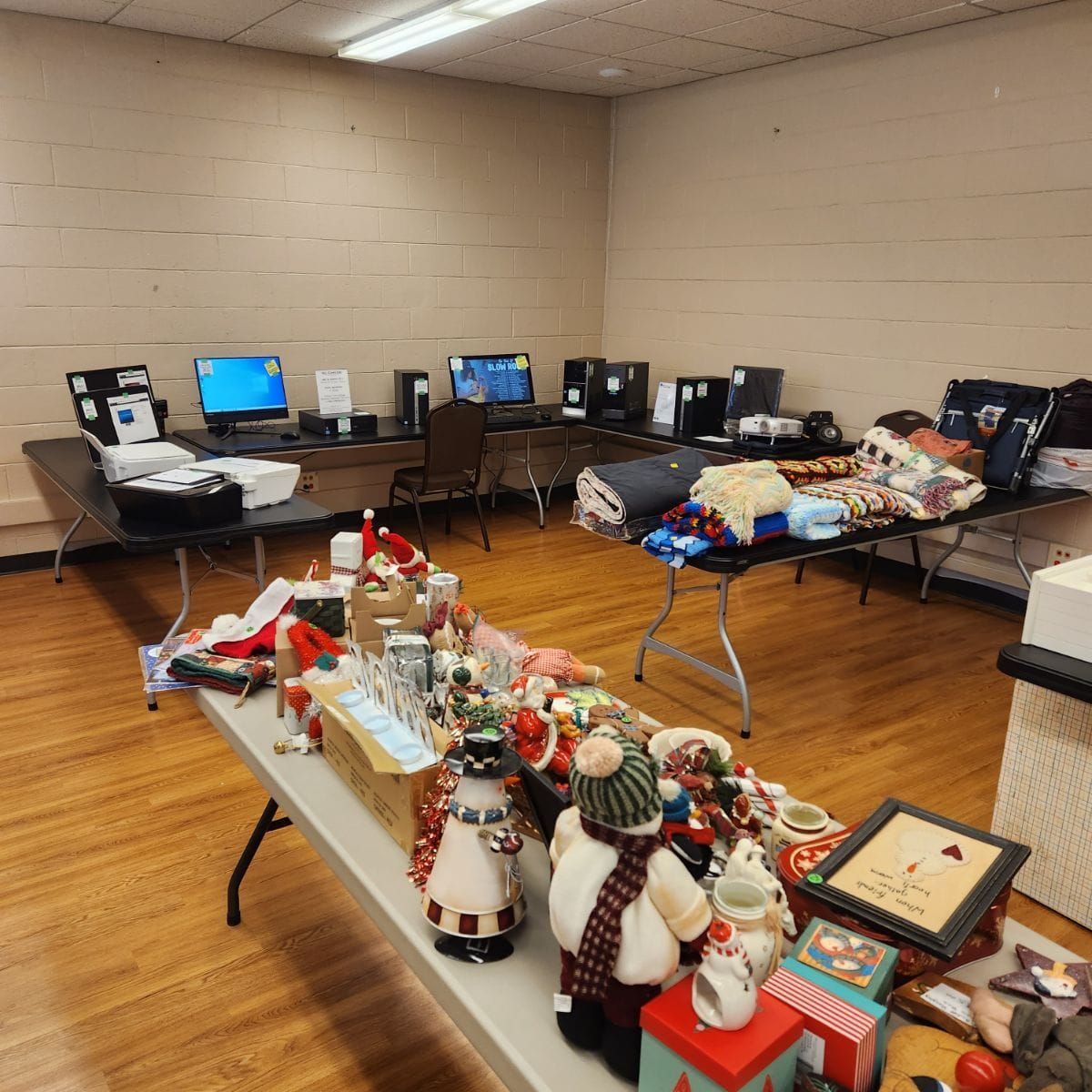 Room with tables displaying Christmas decor and computer setups.