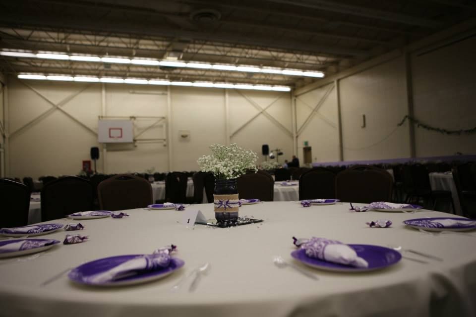 Round table set for a formal event, with purple plates, napkins