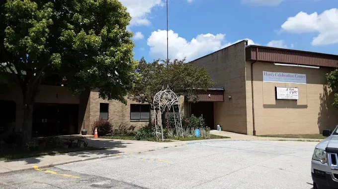 Exterior view of the Southgate Civic Center building with a tree and a car parked in front.