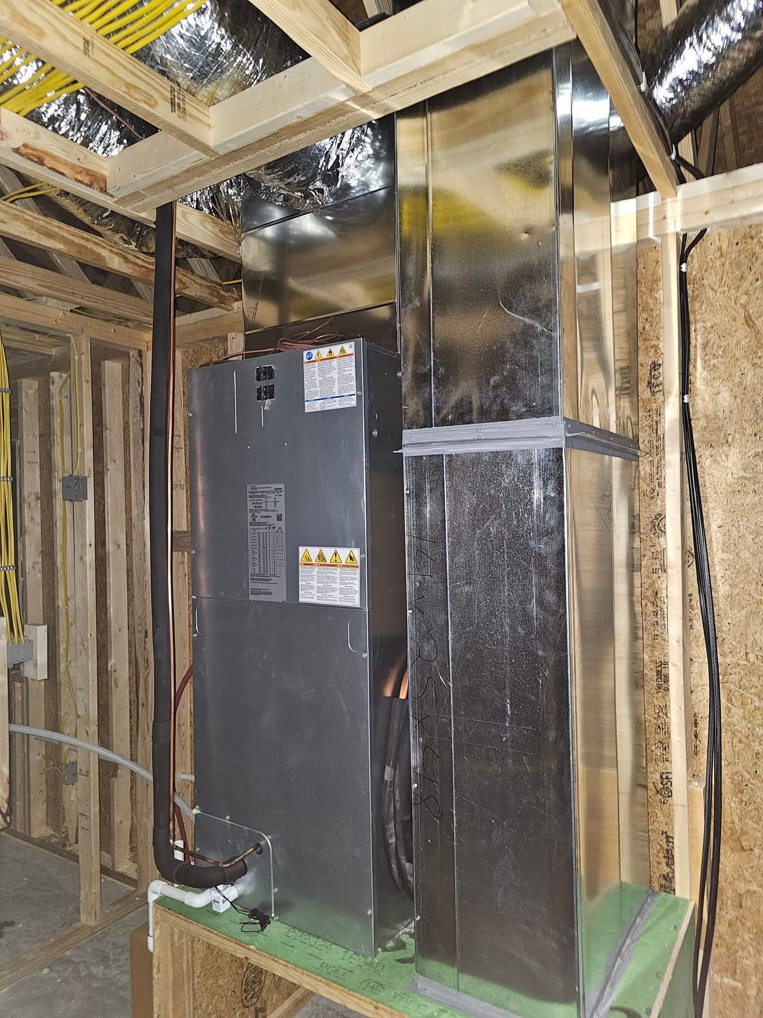 Wall-mounted air conditioner above a window with a patterned curtain. Brown wood paneling surrounds the window.