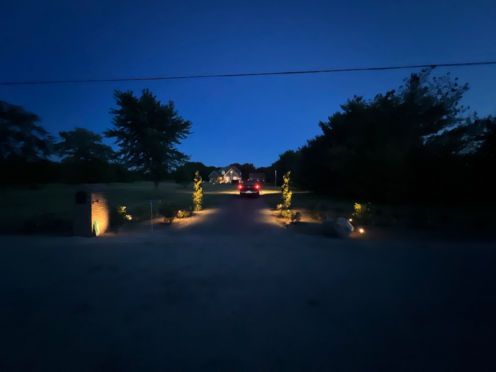 A car is driving down a dirt road at night