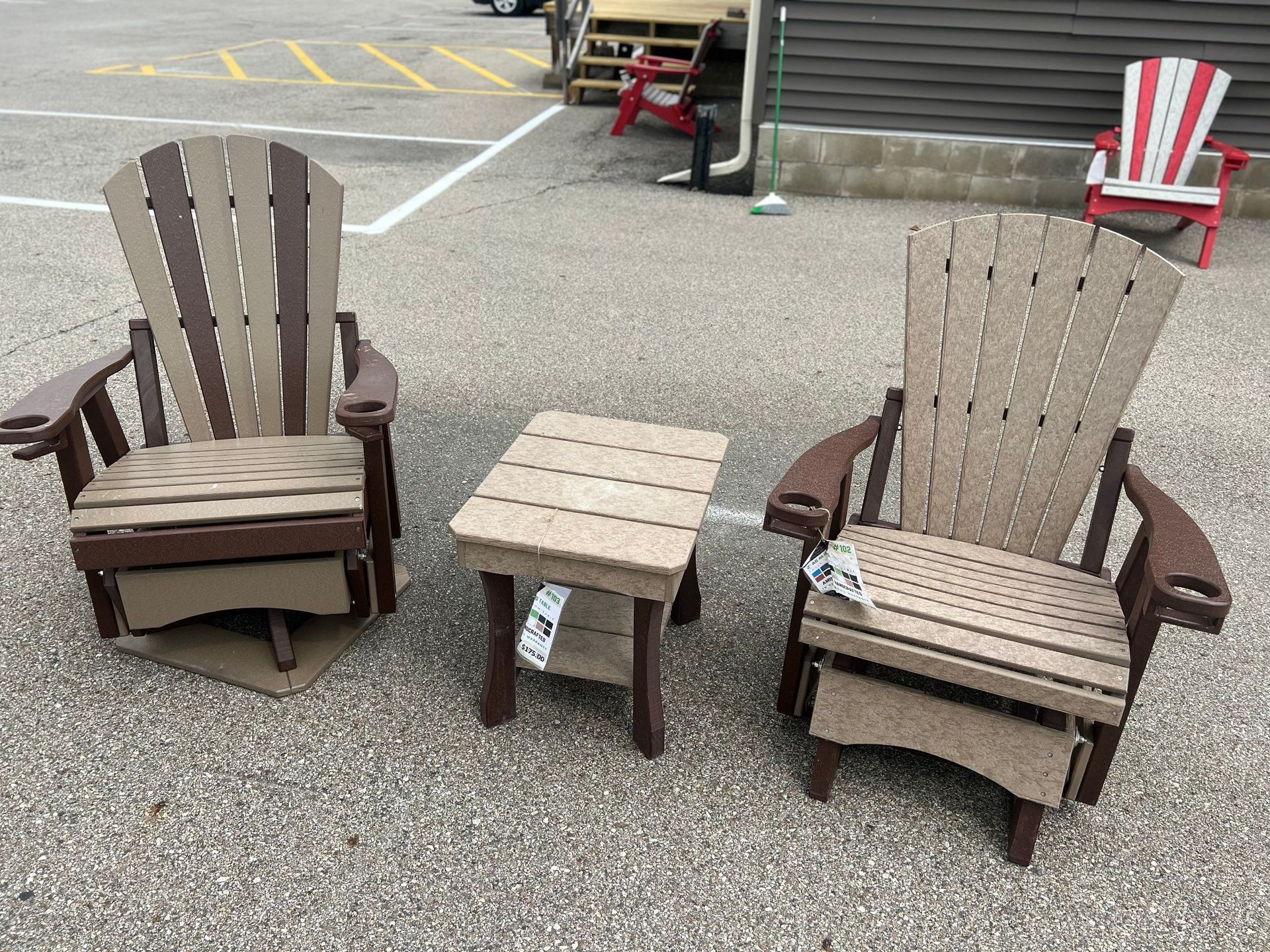 Two chairs and a table are sitting in a parking lot.