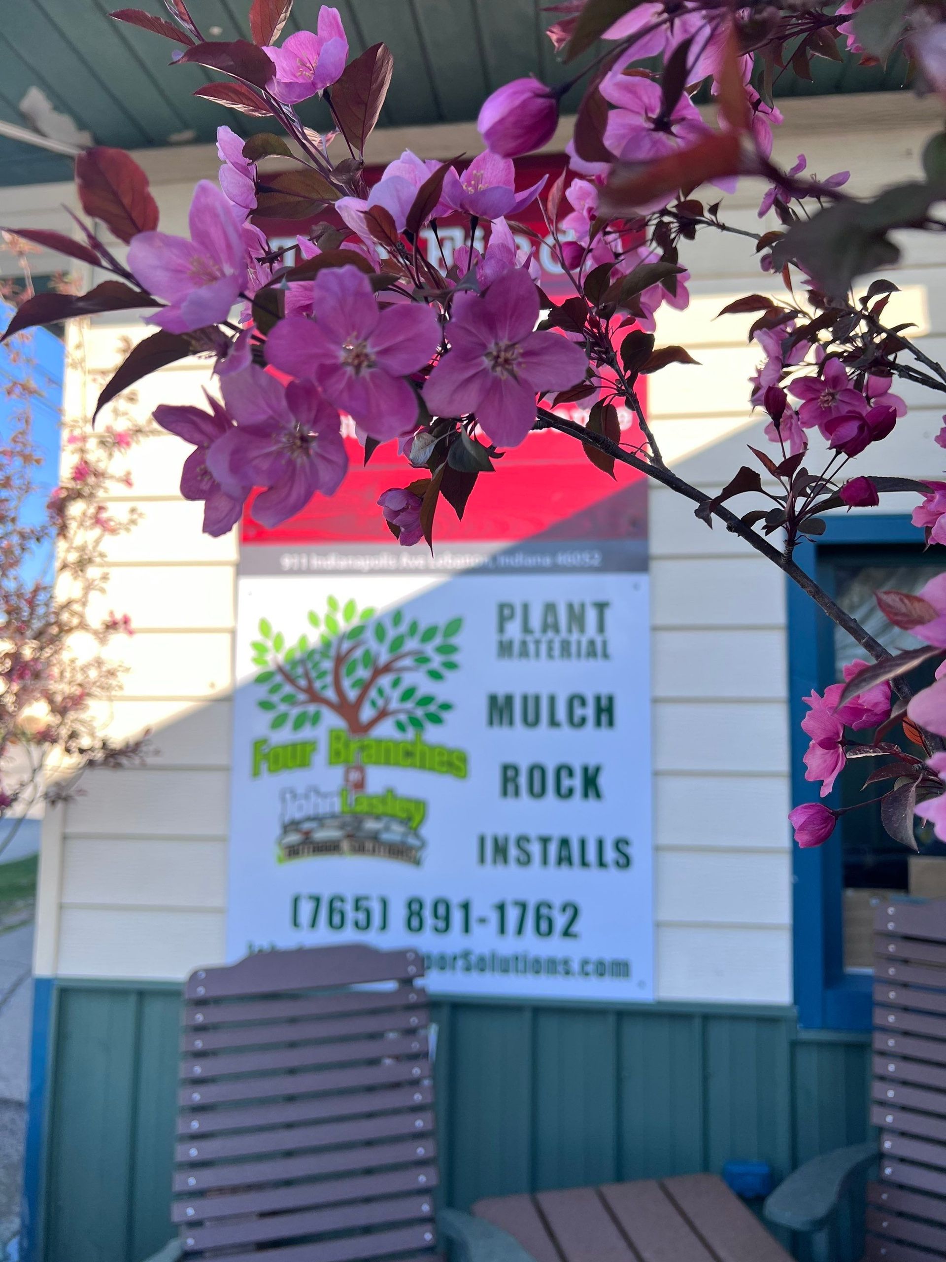 A sign that says plant material mulch rock installs