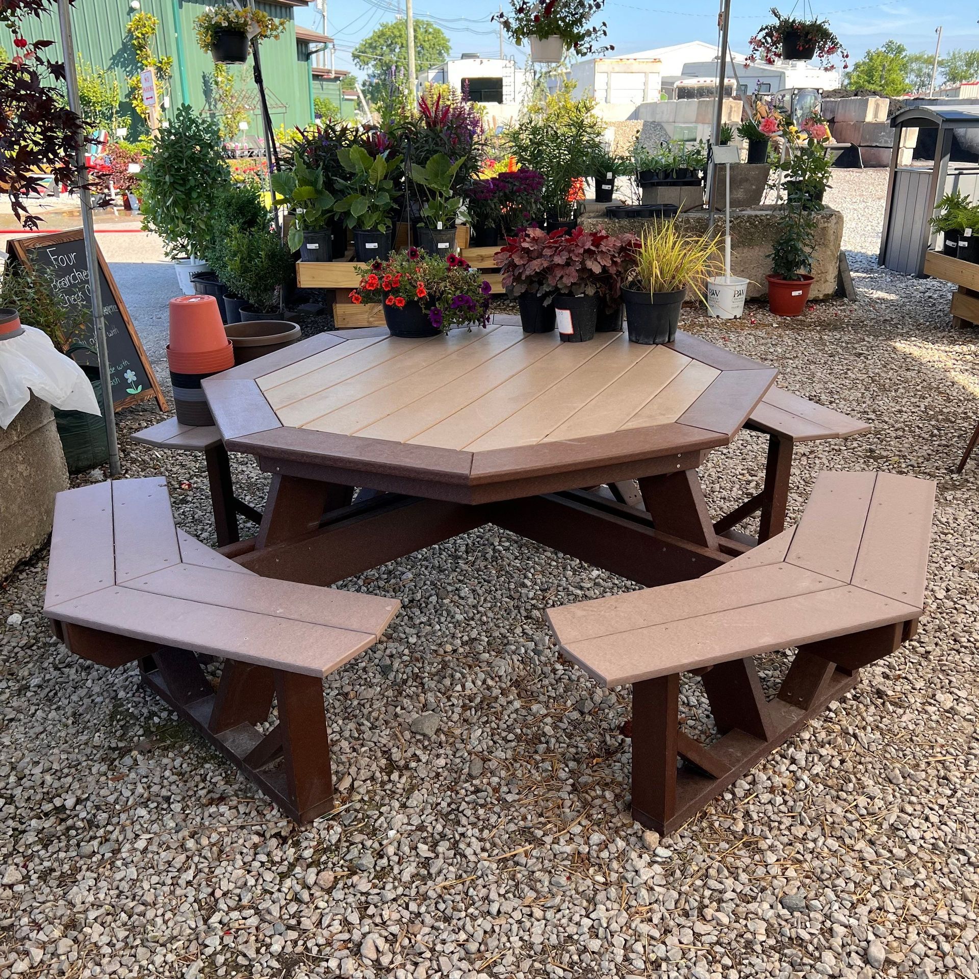 A picnic table with benches in a gravel area
