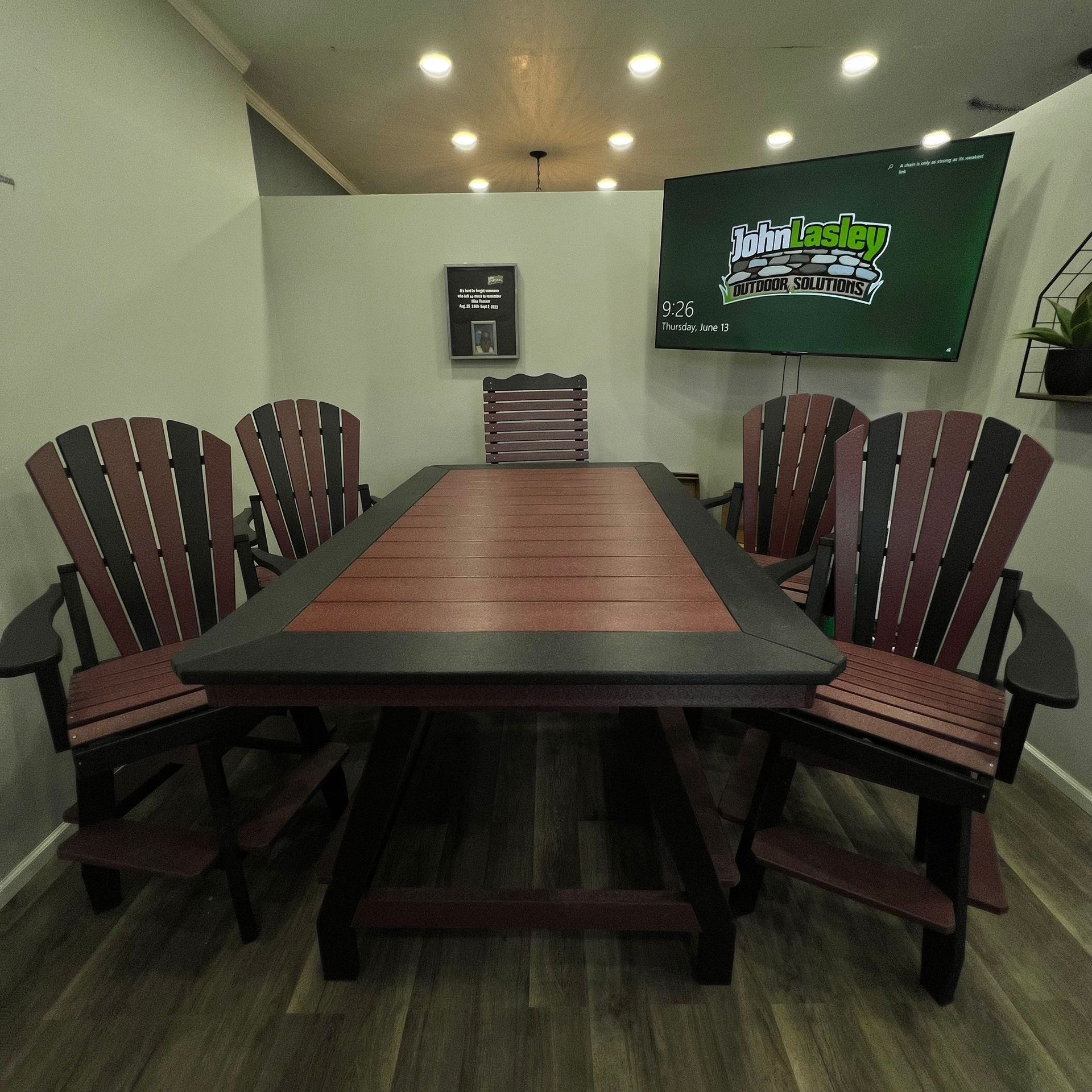 A table and chairs in a room with a tv on the wall
