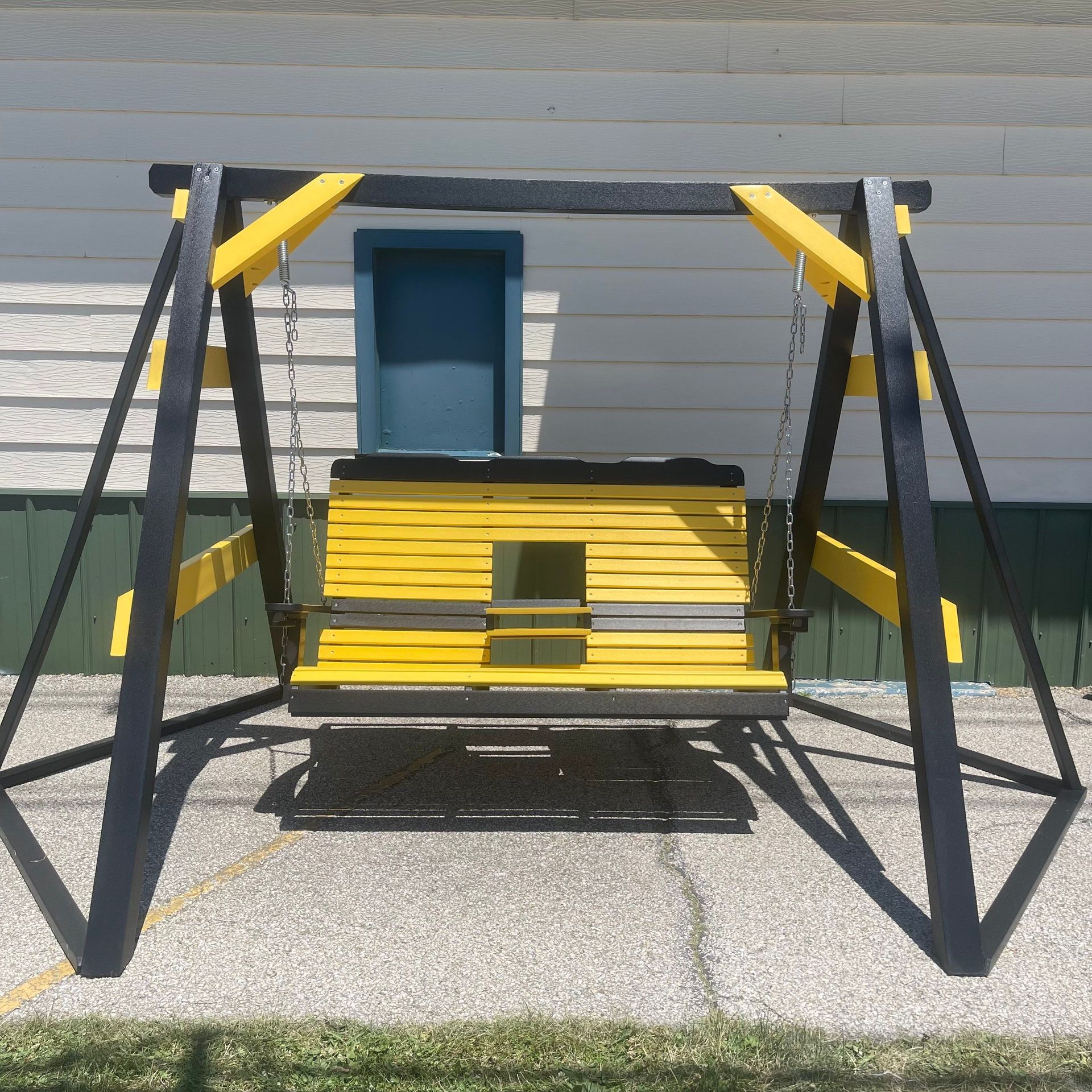 A yellow and black swing is in front of a house