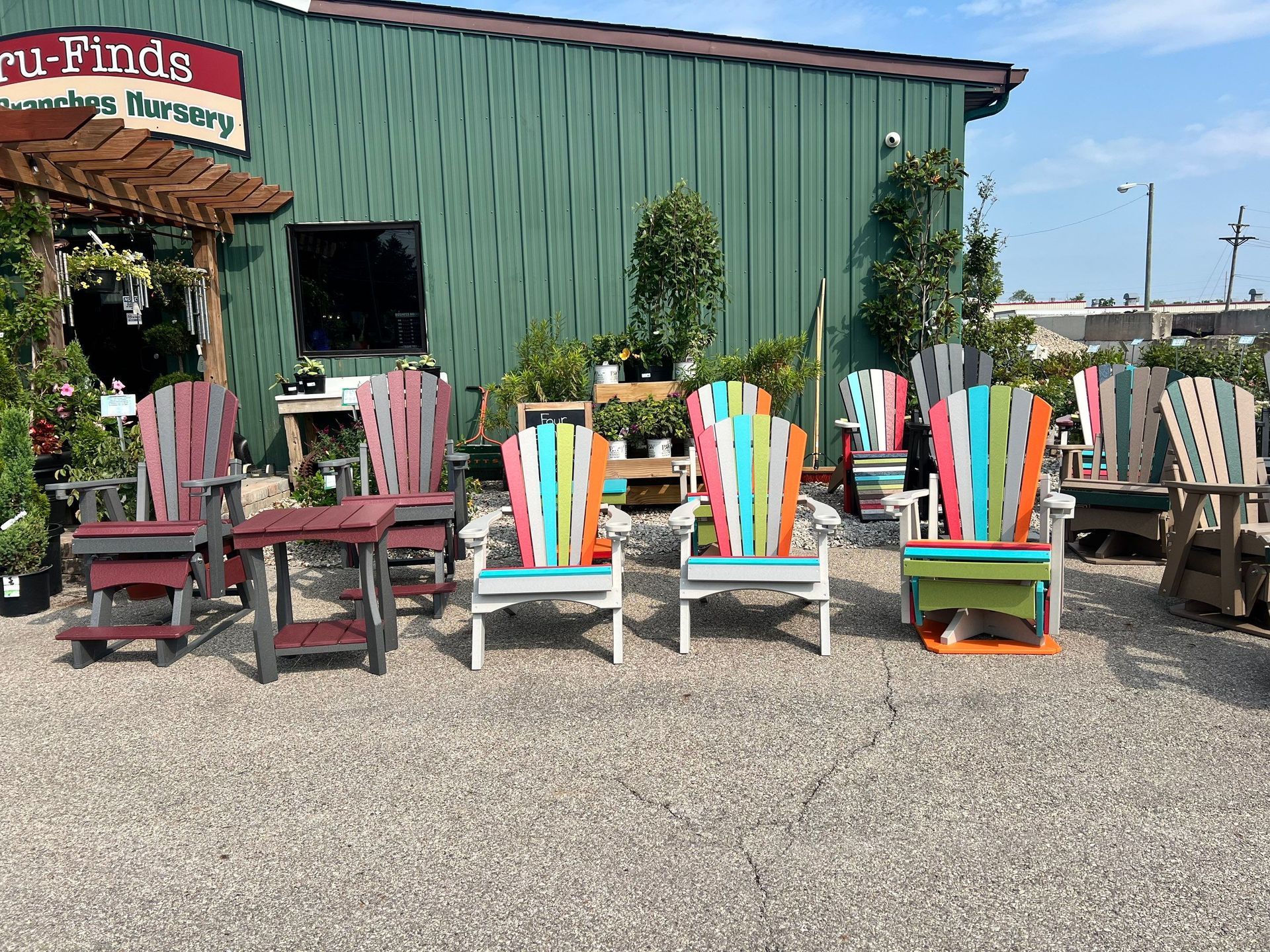 A bunch of colorful chairs are sitting in front of a building.