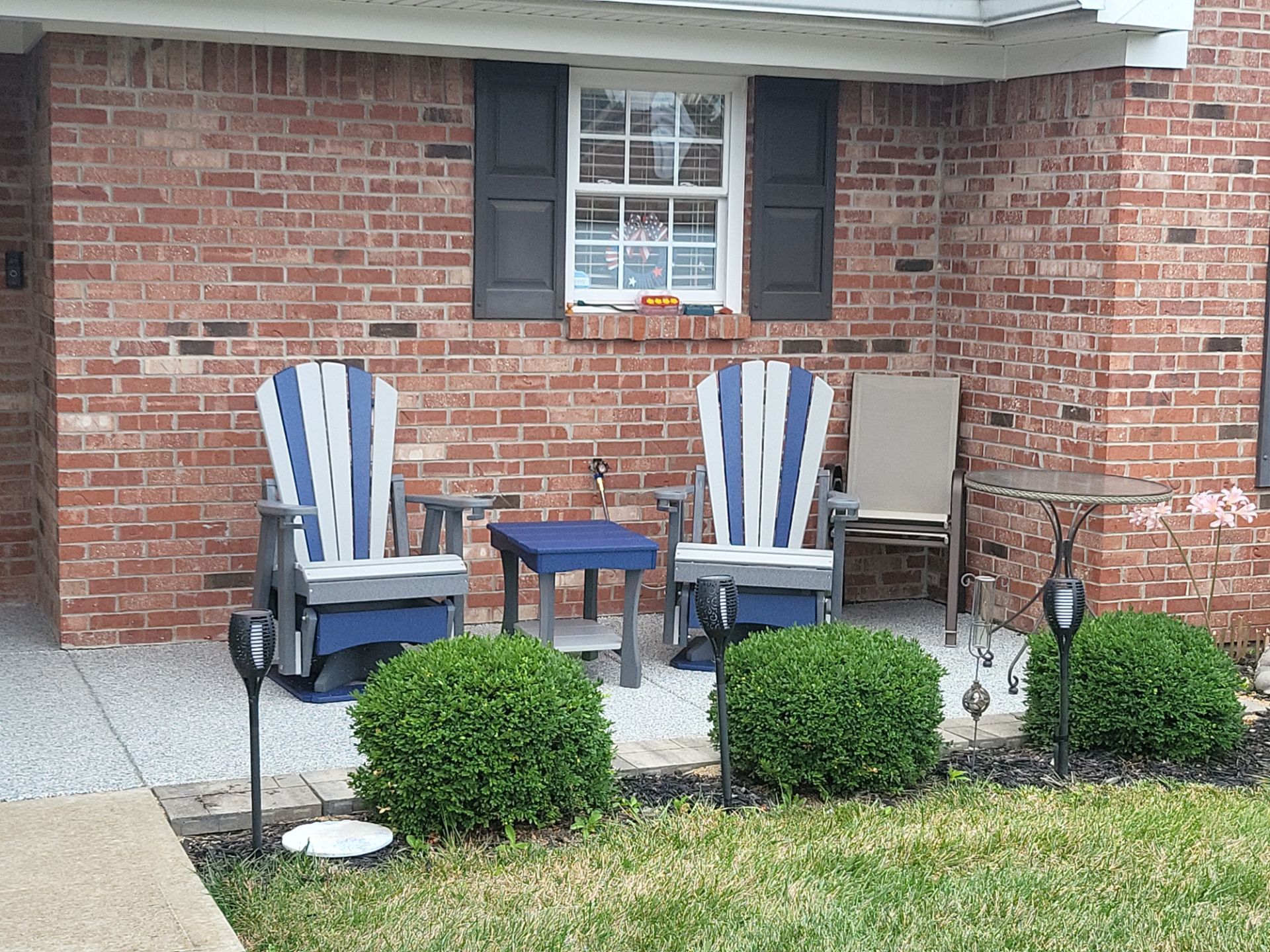 A brick house with two chairs and a table in front of it