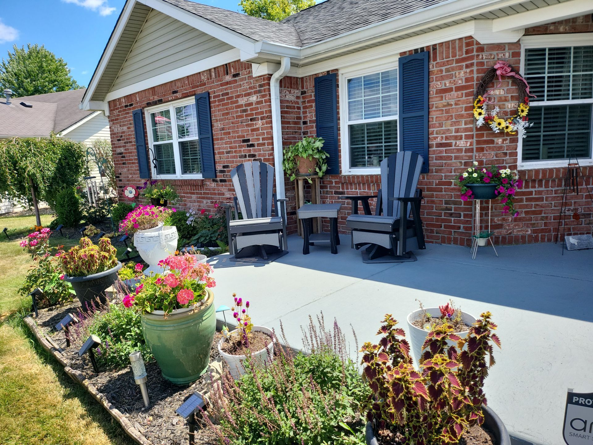 A brick house with a patio and chairs in front of it.