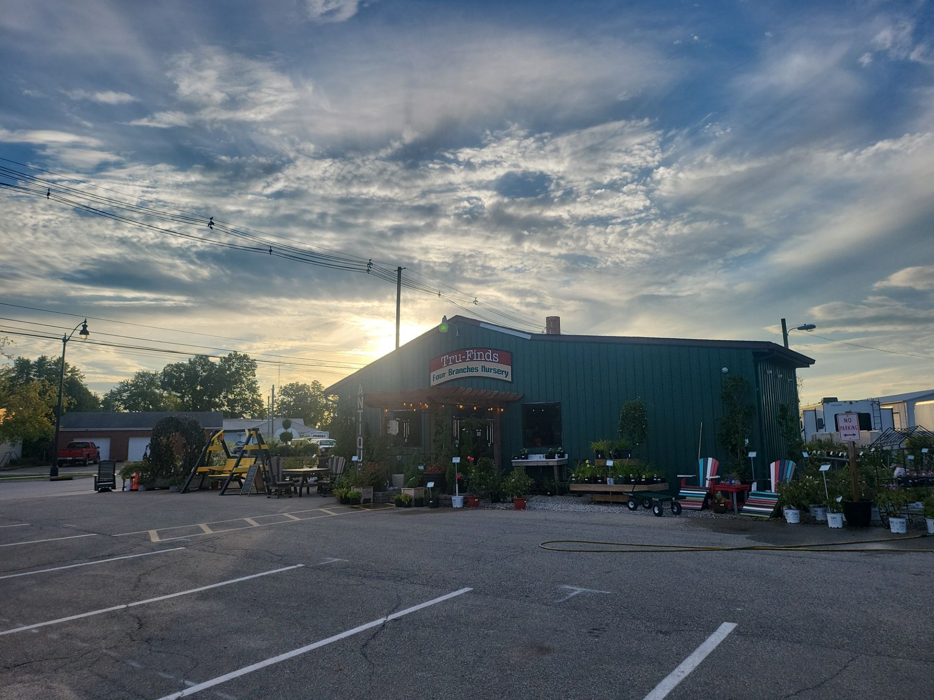 A large green building with a lot of potted plants in front of it.