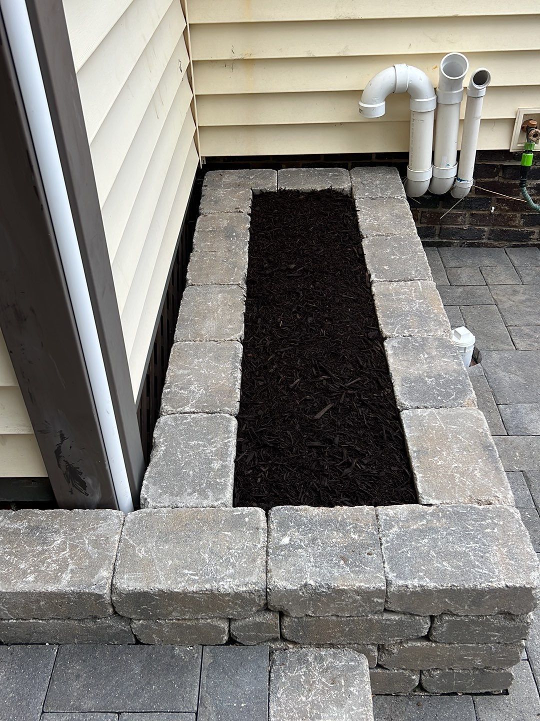 A brick wall with a planter in the middle of it