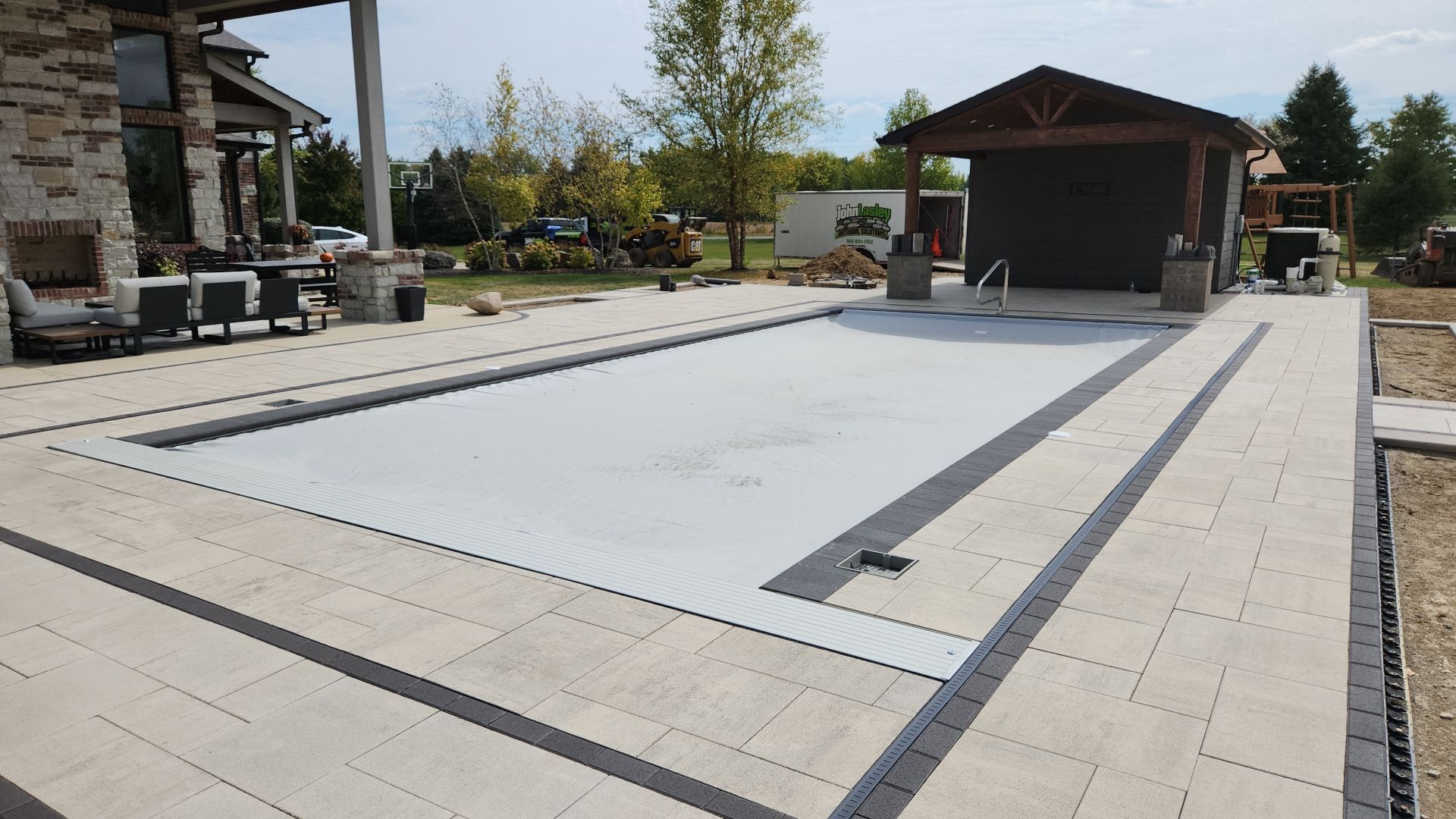 A large swimming pool is being built in the backyard of a house.