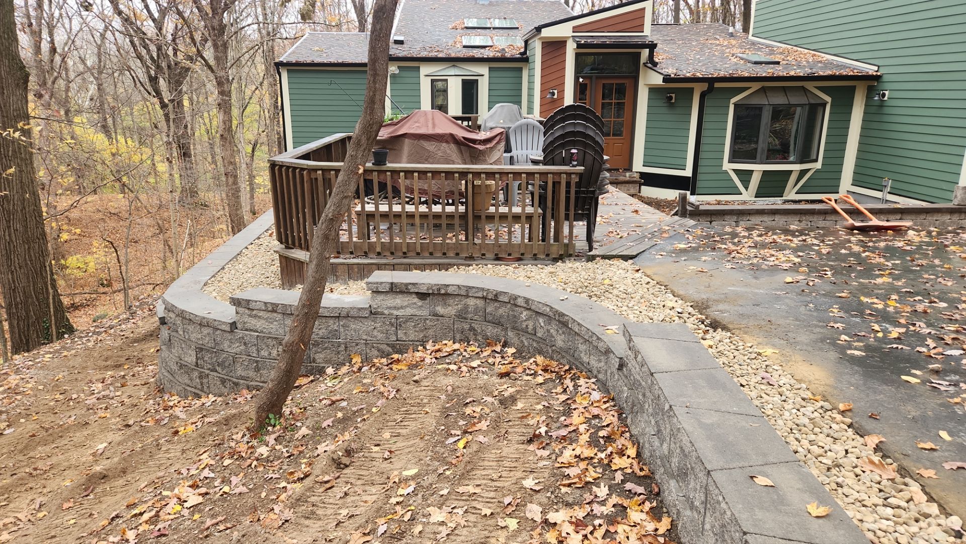 A green house with a deck and a walkway in front of it.