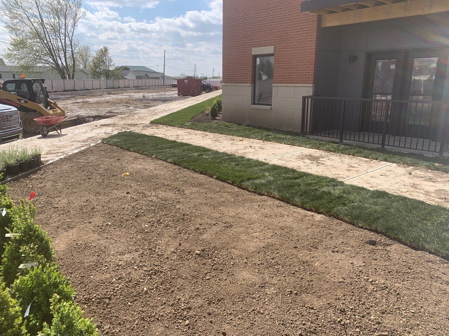 A brick building is being built next to a grassy field.