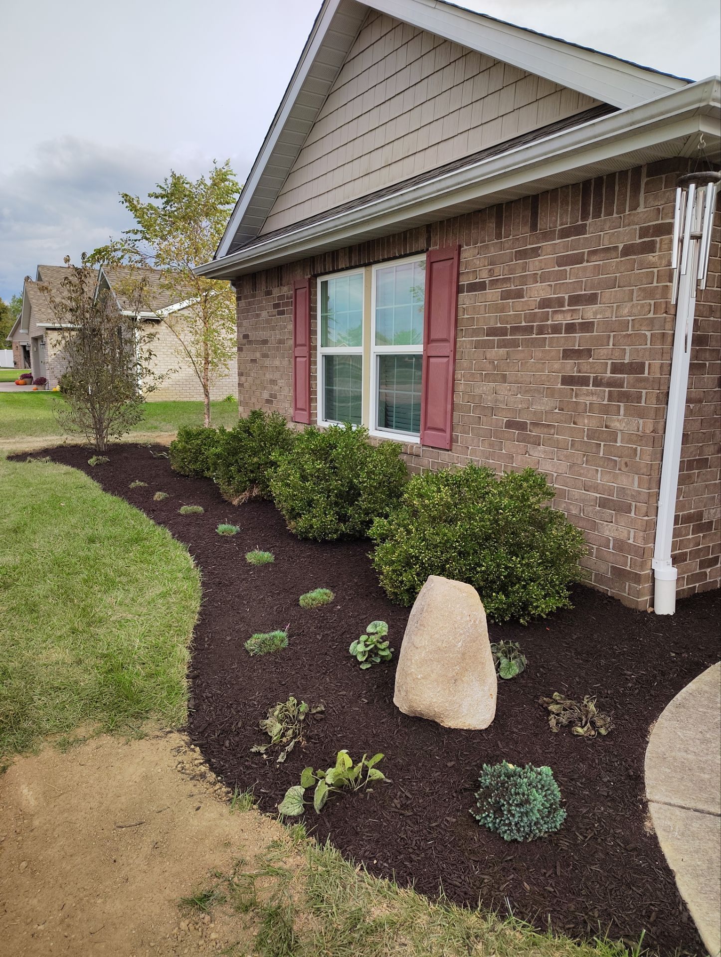 A brick house with a large rock in front of it.