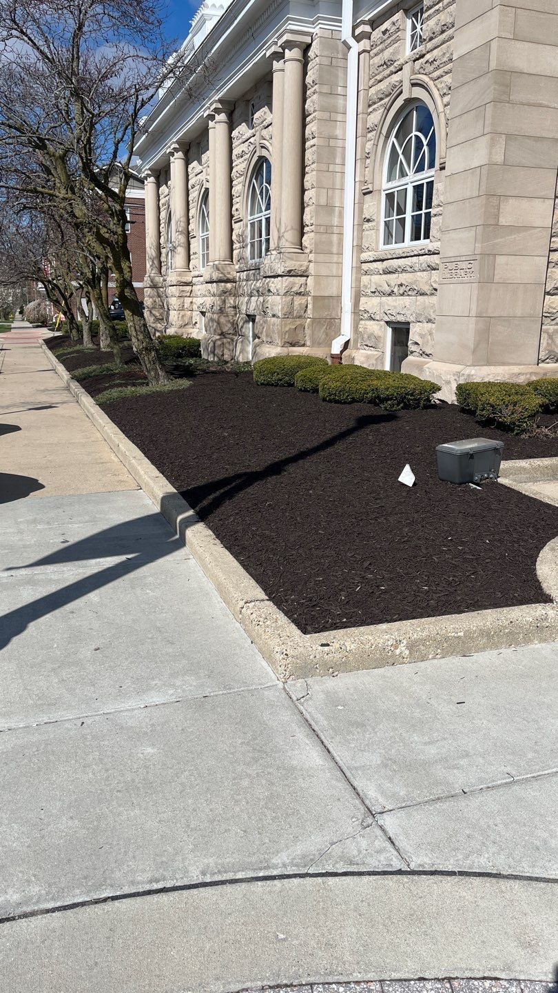 A brick building with a lot of mulch in front of it.