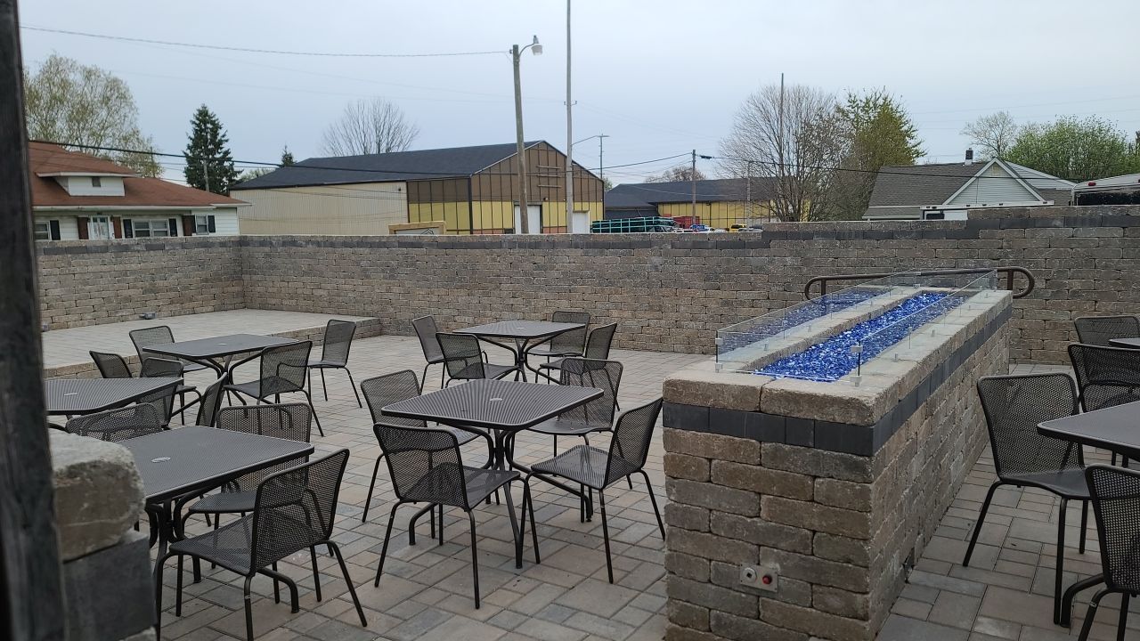 A patio with tables and chairs and a fire pit.