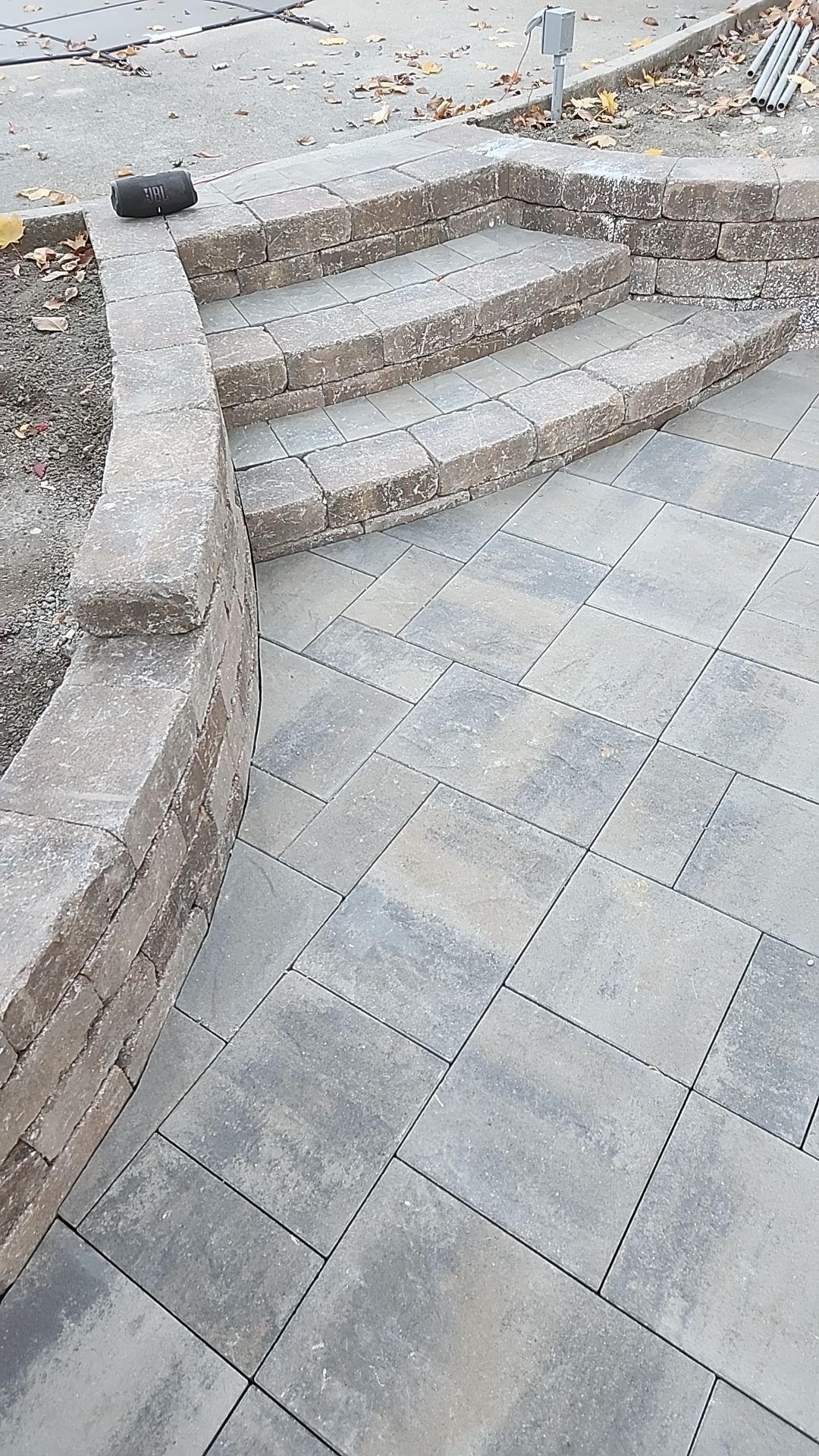 A set of steps leading up to a stone wall on a patio.