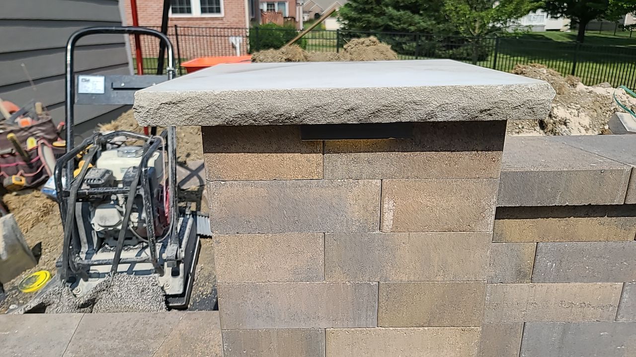 A machine is sitting on top of a brick wall.