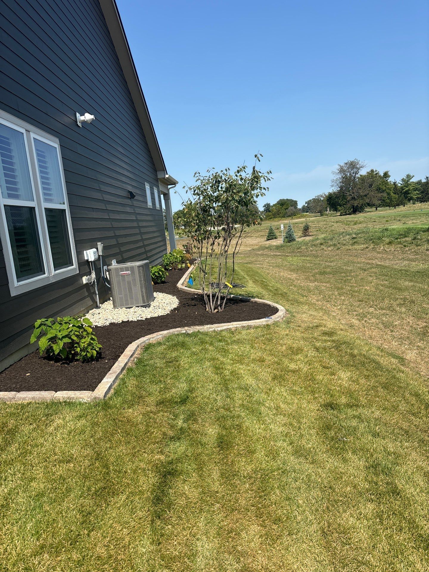 A house with a lush green lawn in front of it.
