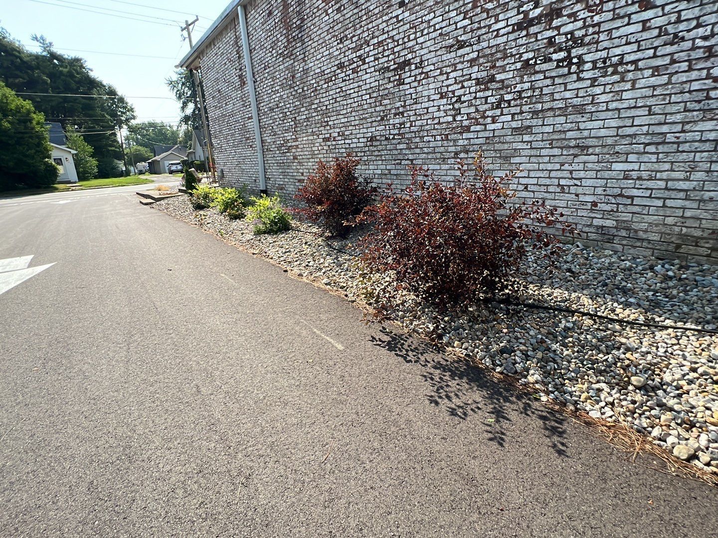 A brick wall along the side of a road next to a road.