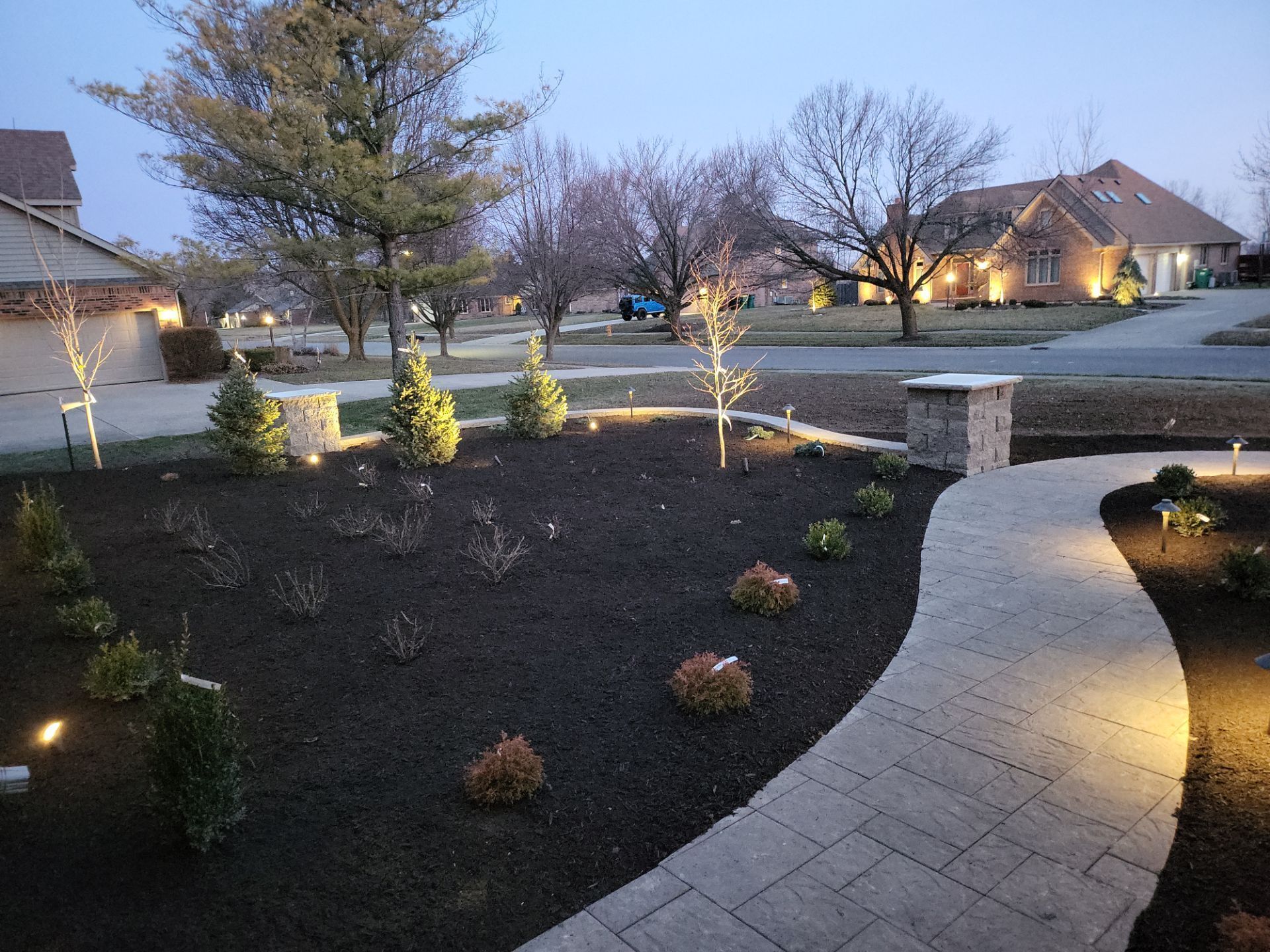 A walkway leading to a house is lit up at night