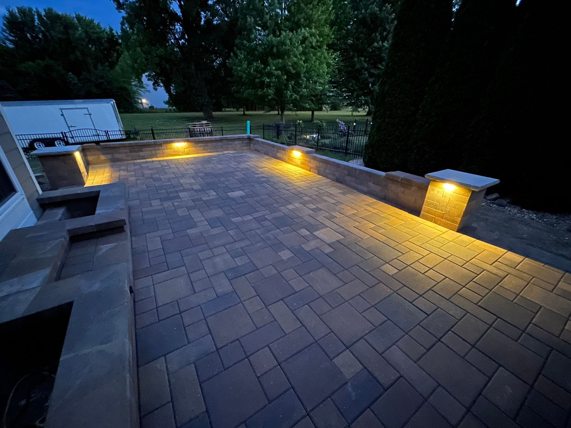 A brick patio with lights on it at night.