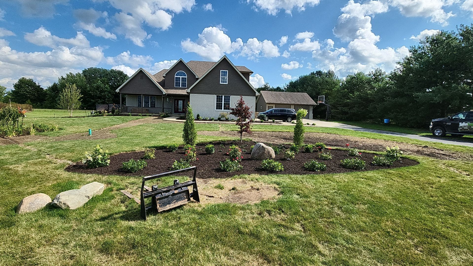 A large house is sitting in the middle of a lush green field.
