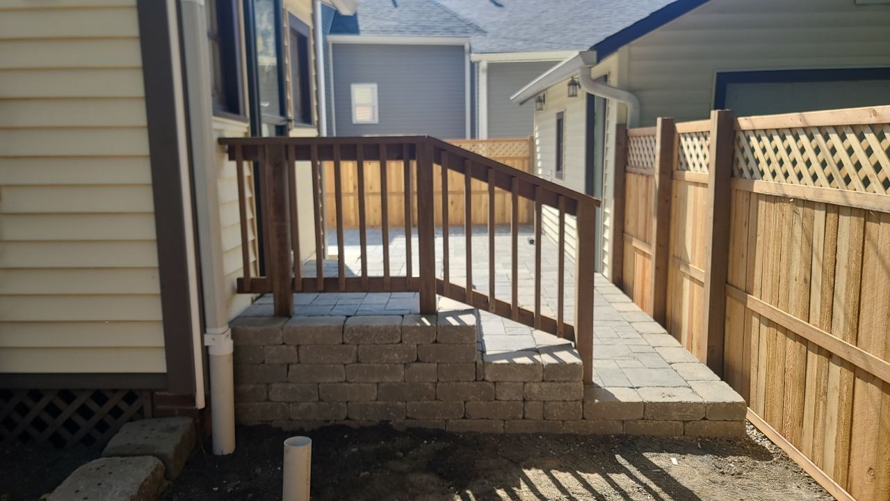 A wooden deck with stairs and a wooden fence