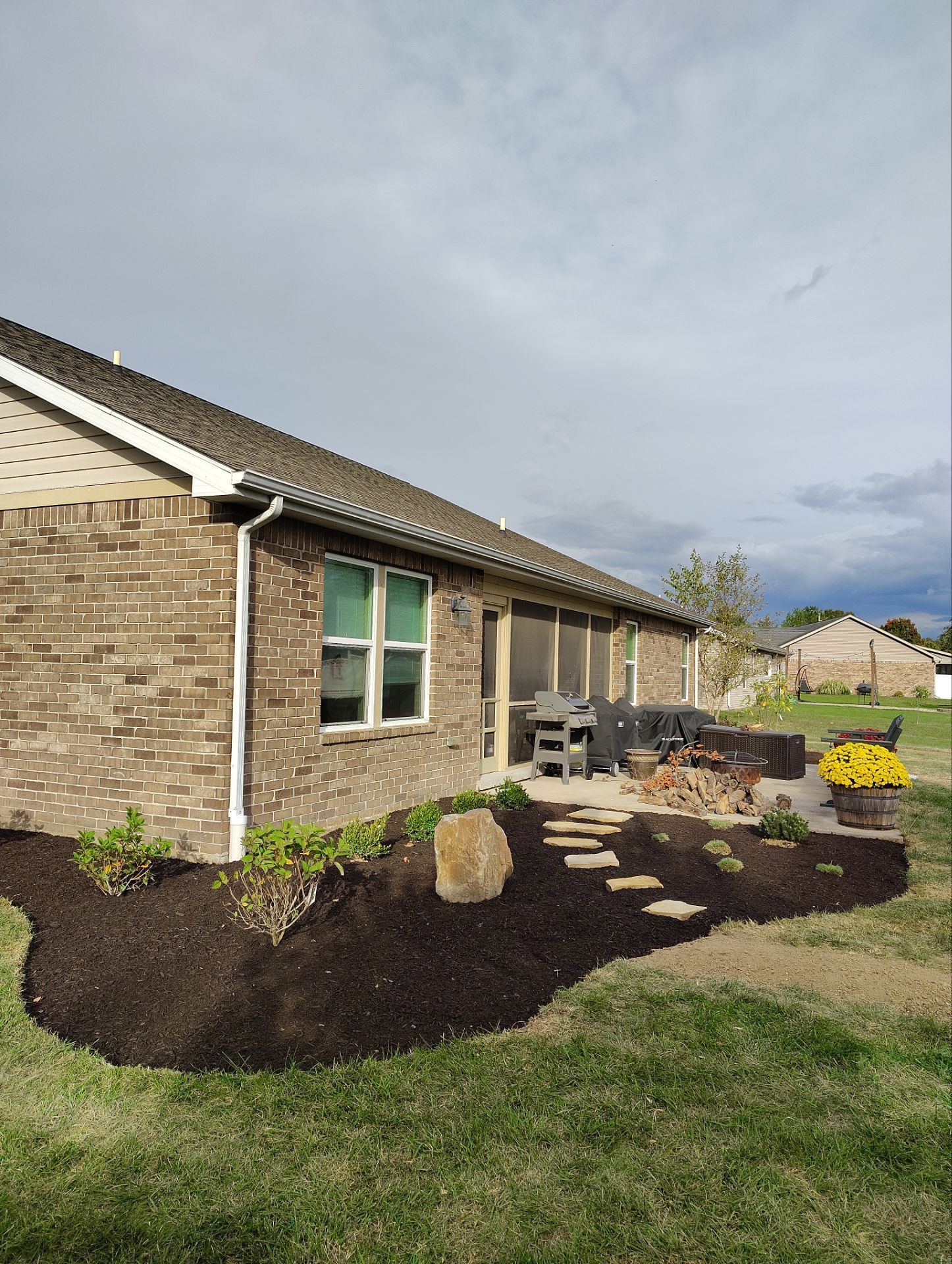 A brick house with a patio in front of it.