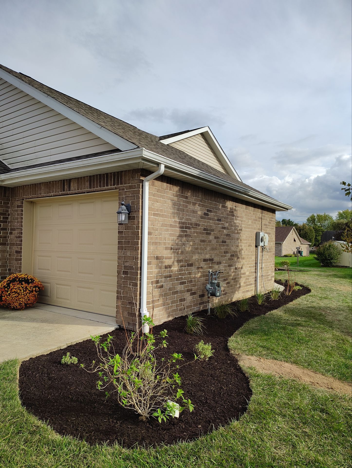 A house with a garage and a lawn in front of it.