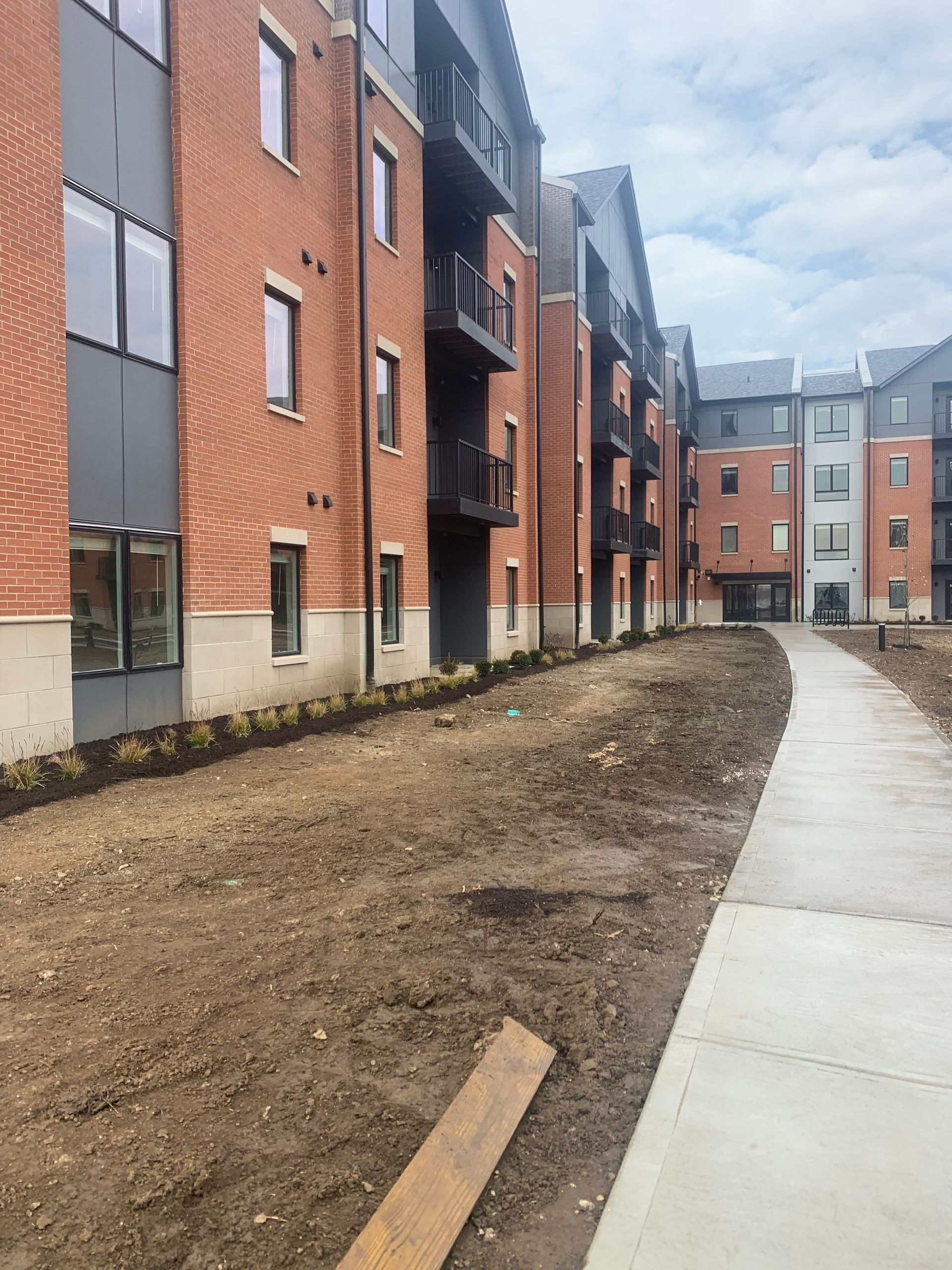 A row of brick buildings with a sidewalk in front of them