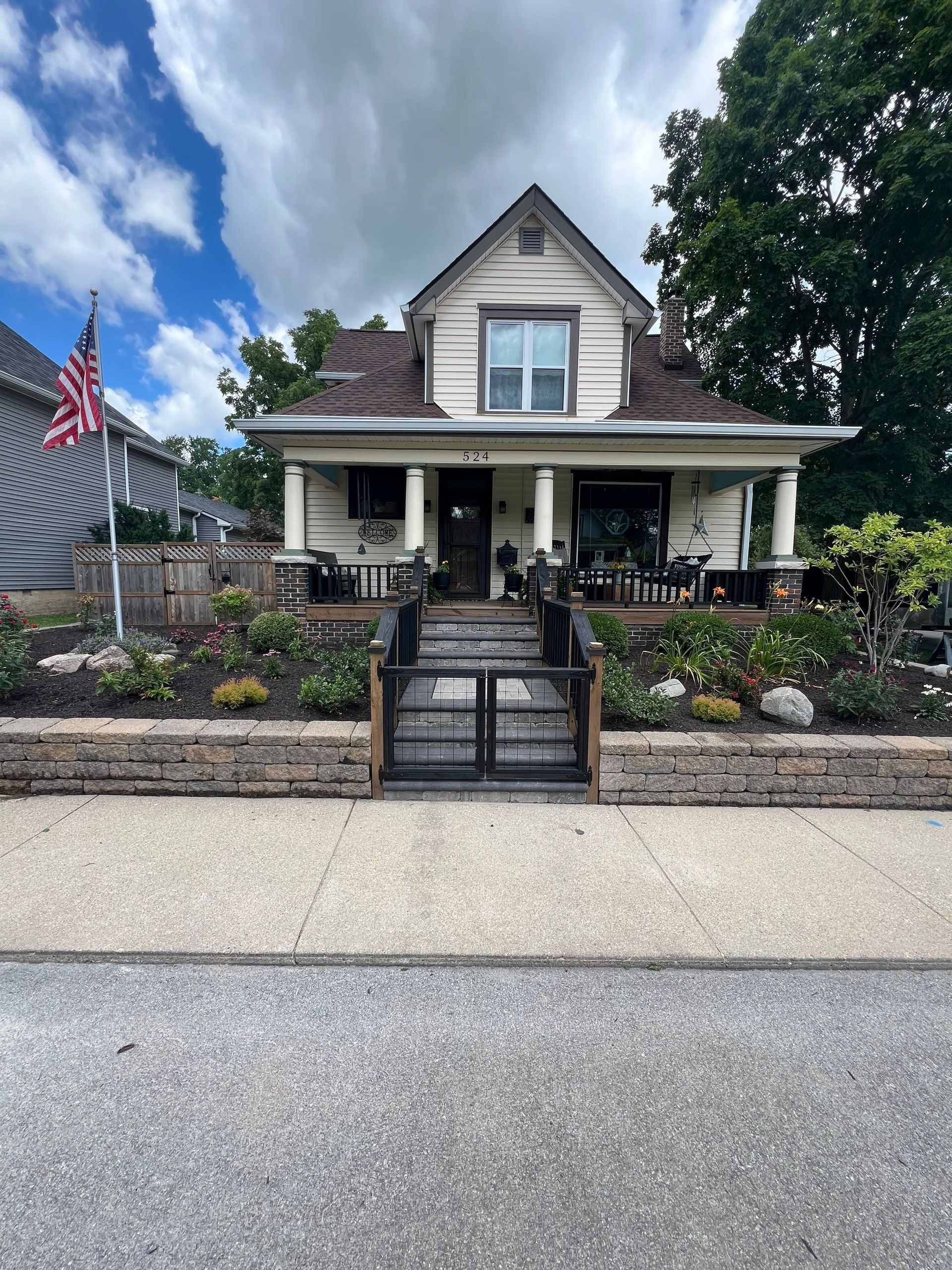 A house with a fence and a flag in front of it.