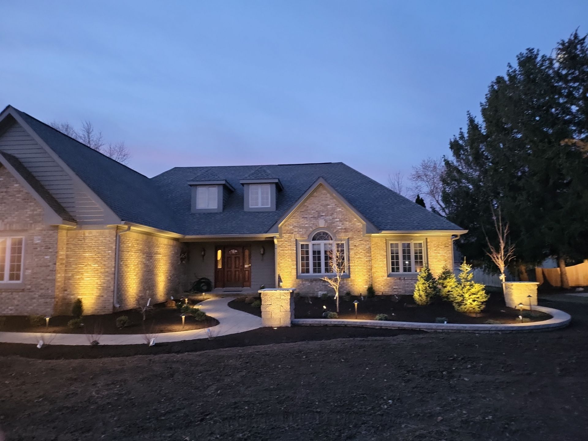 A large brick house is lit up at night.