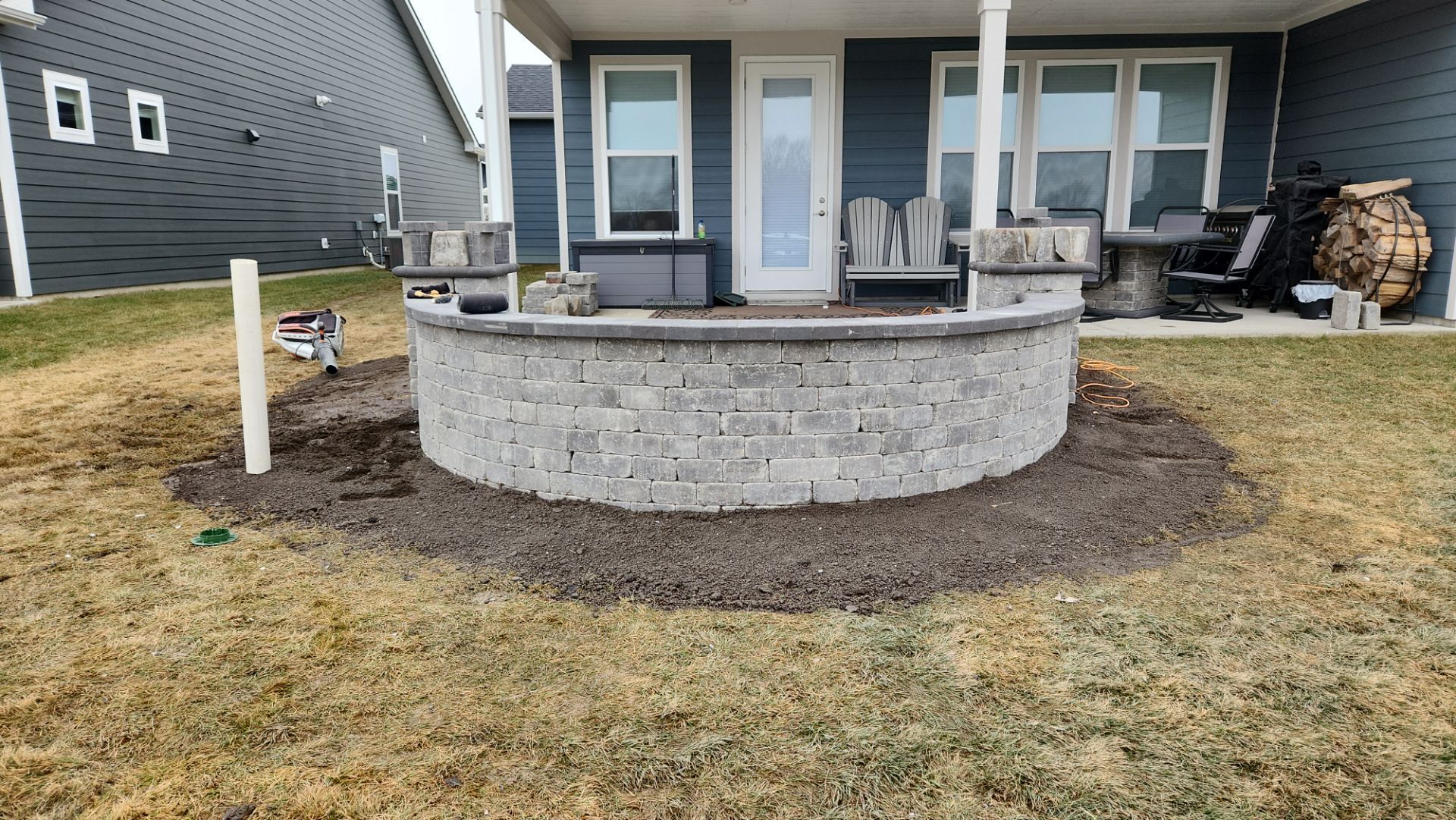 A brick wall is being built in front of a house.
