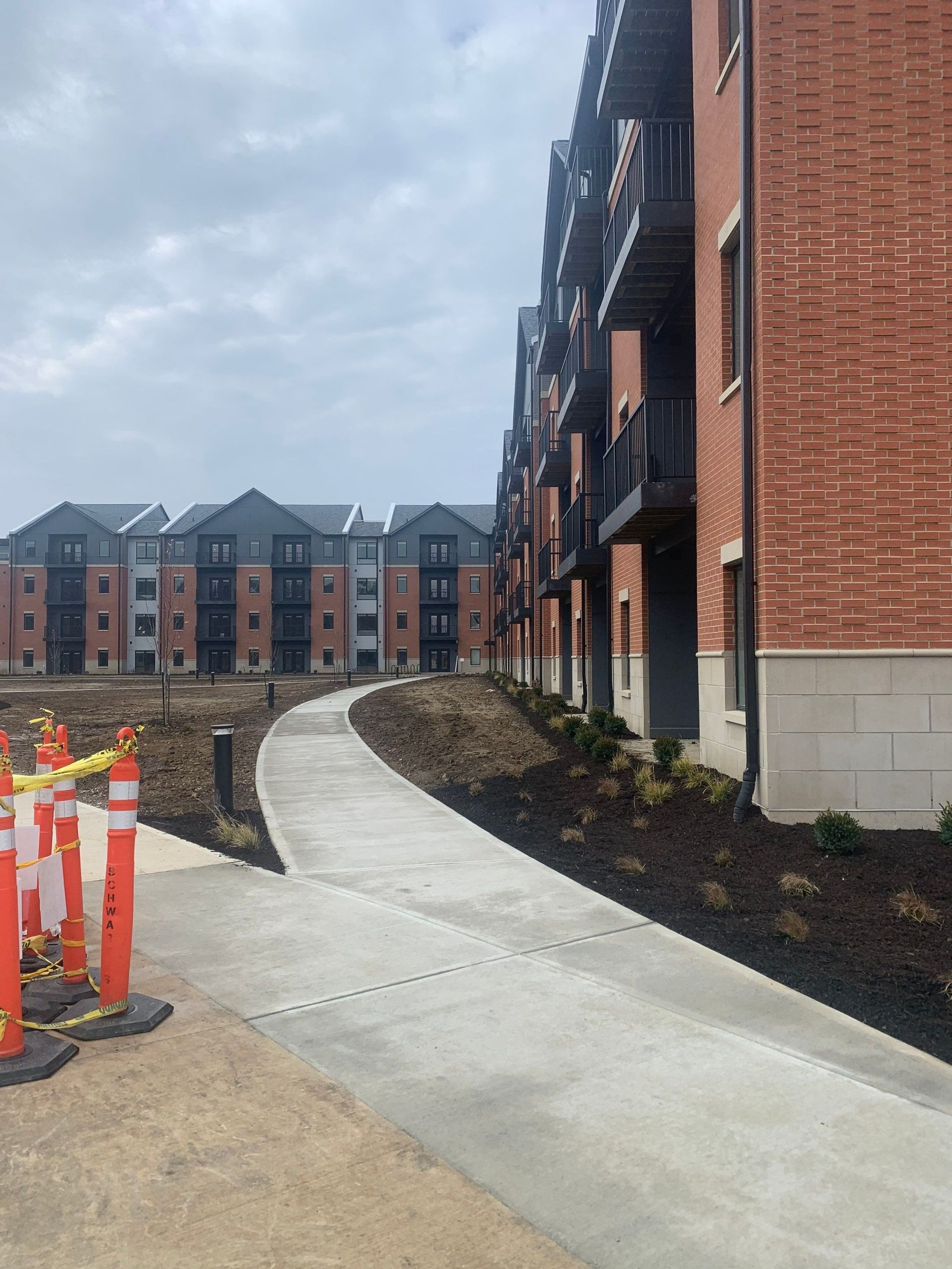 A brick building with a concrete walkway leading to it.