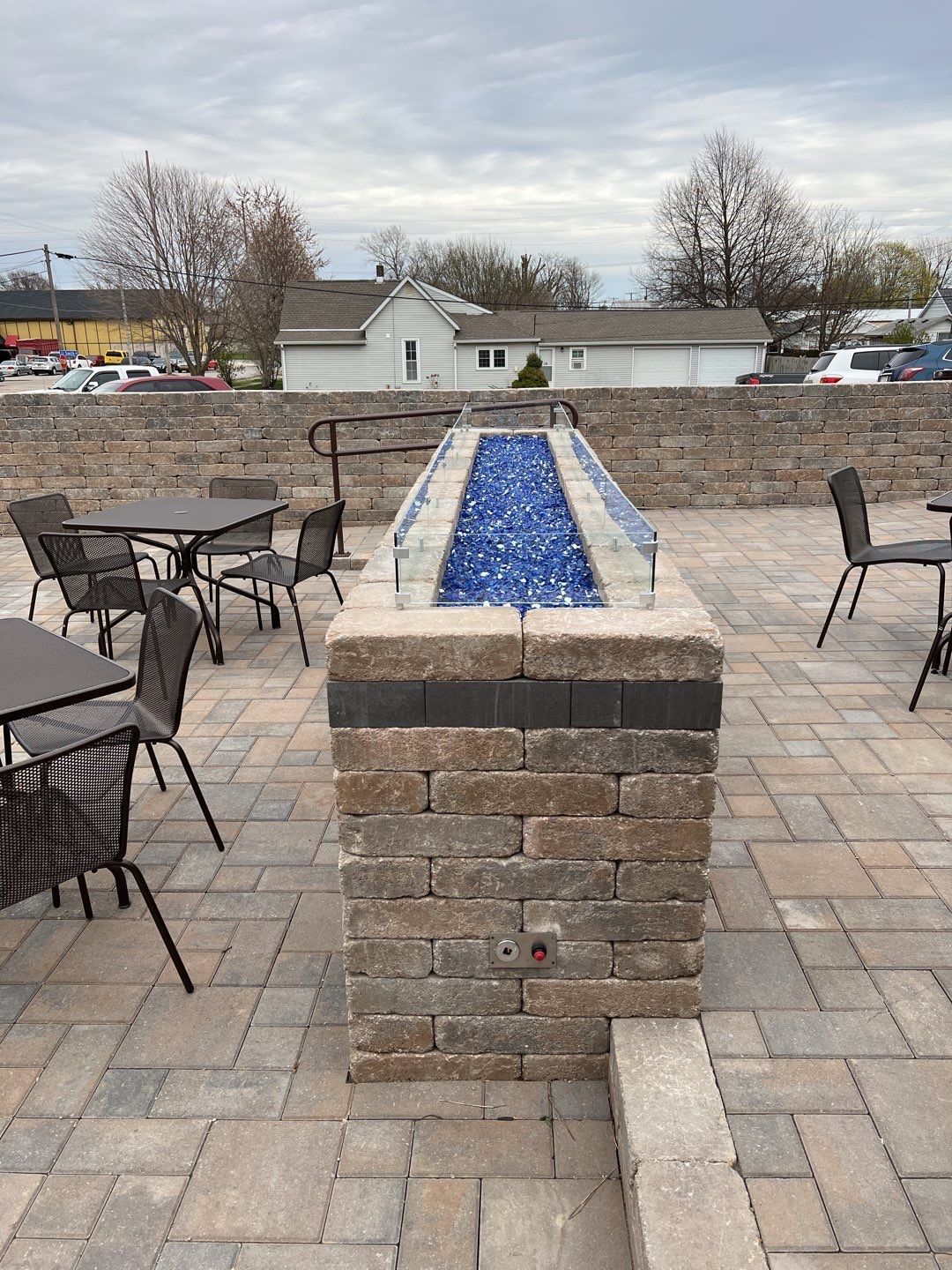 A patio with tables and chairs and a fire pit.