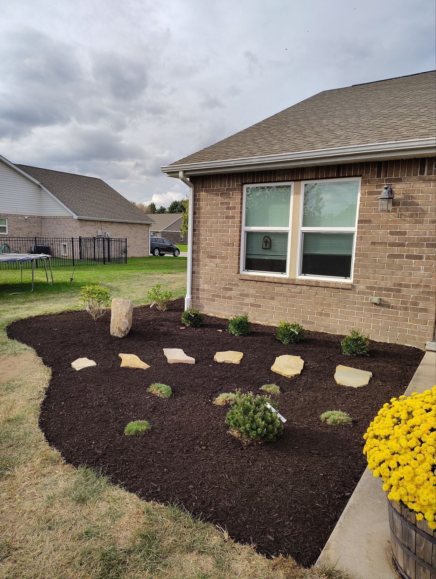 A brick house with a garden in front of it.