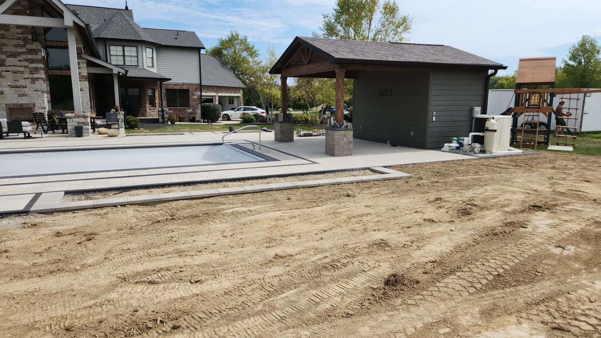 A swimming pool is being built in the backyard of a house.