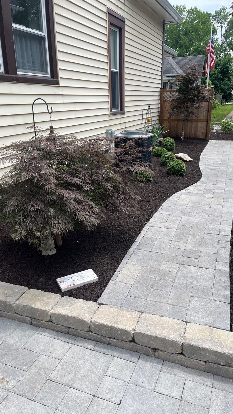 There is a walkway leading to the front of the house.