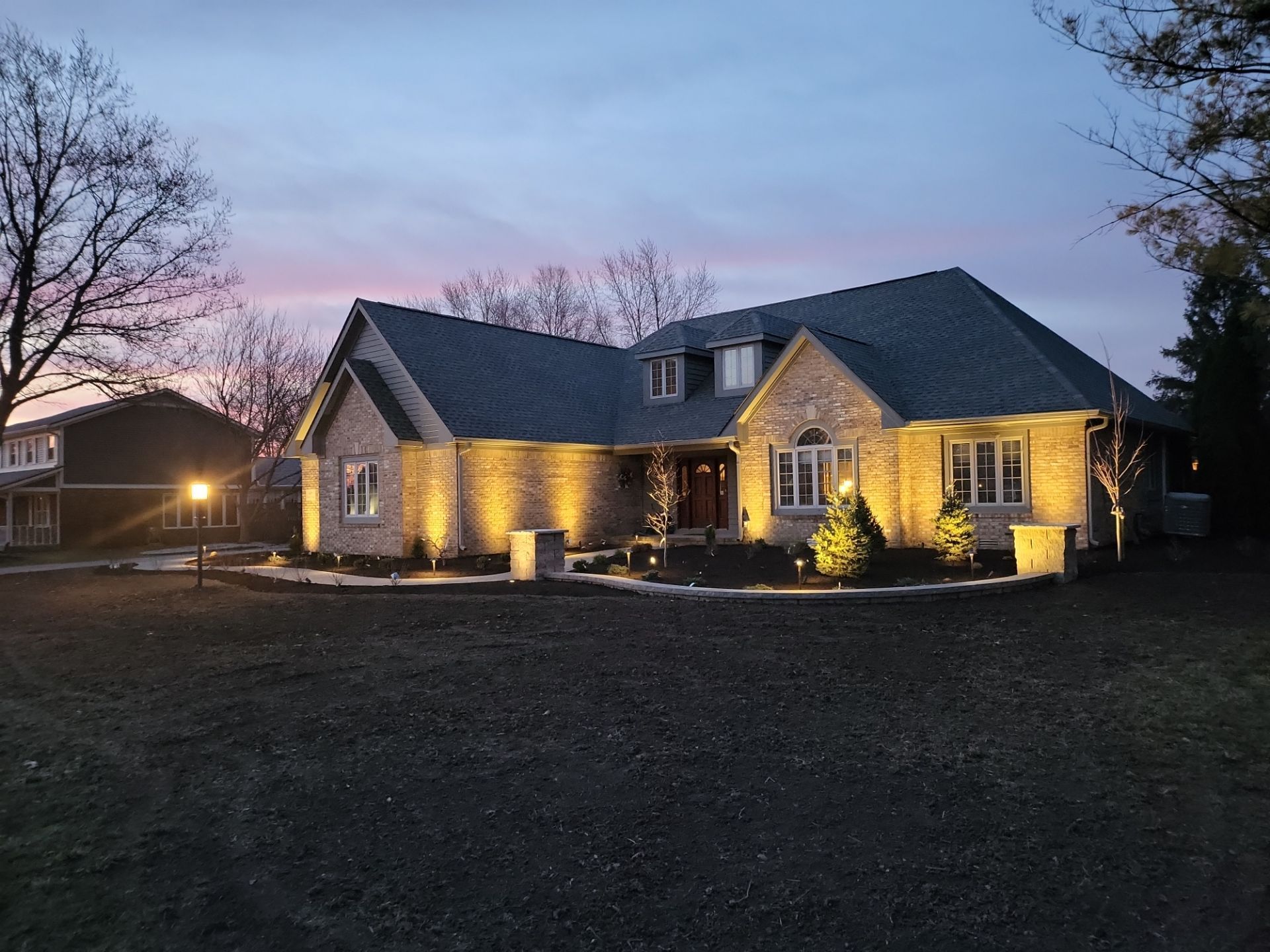 A large house with a lot of lights on it is lit up at night.